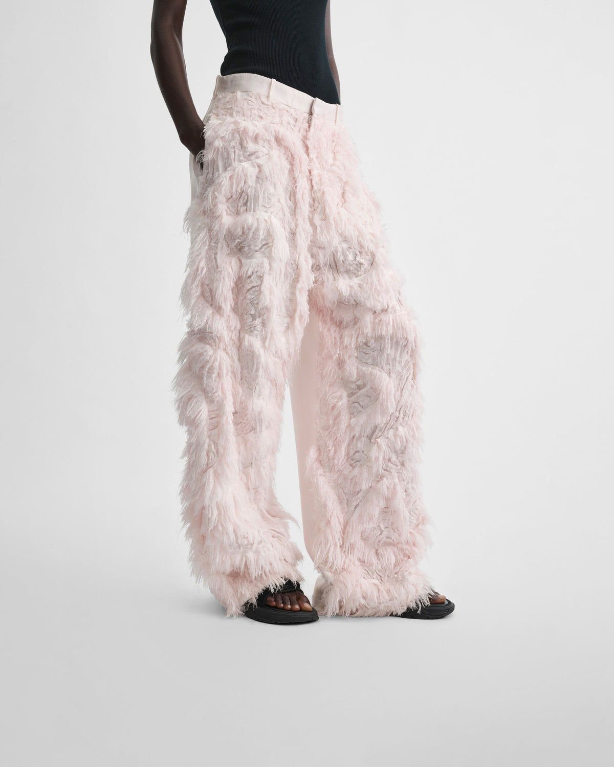 Angled front view of model wearing COMBED EMBROIDERED TROUSERS in floss viscose
