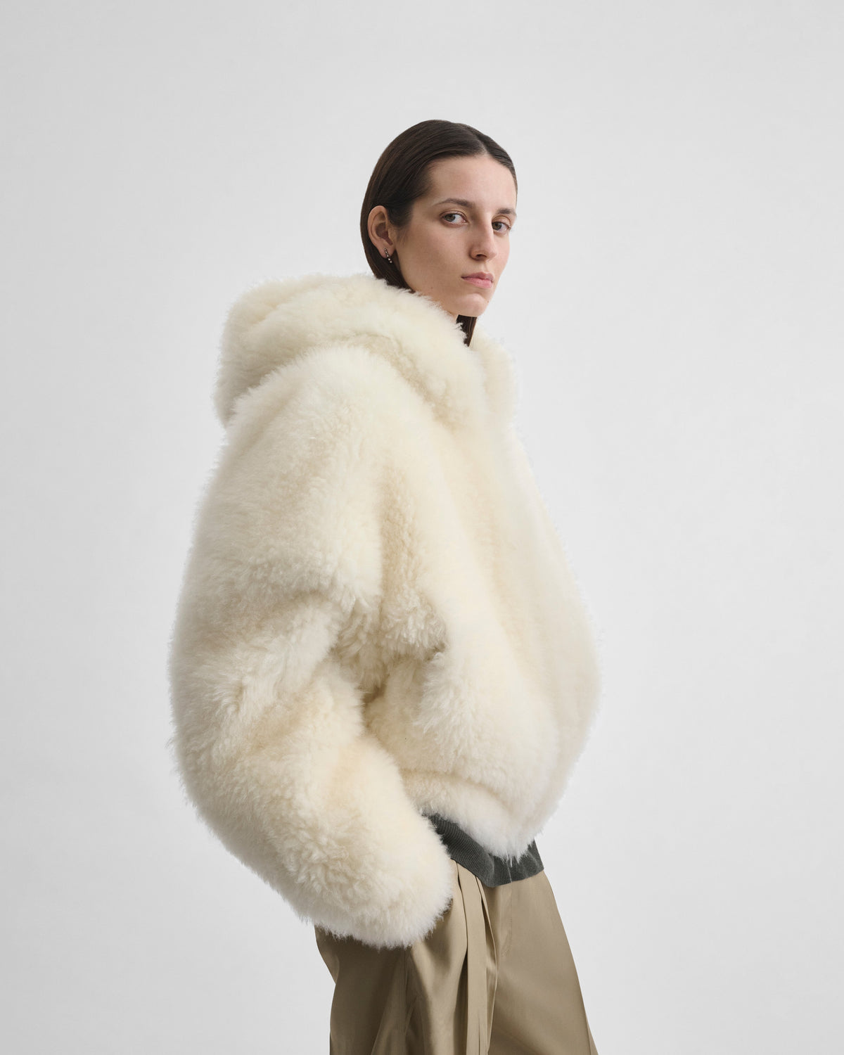 Side view of model wearing SUPER TEDDY HOODIE in ivory shearling