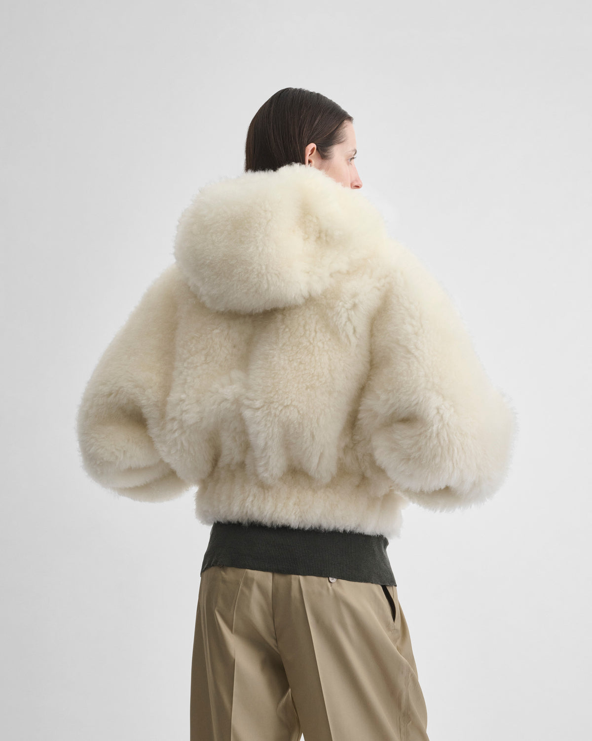 Back view of model wearing SUPER TEDDY HOODIE in ivory shearling