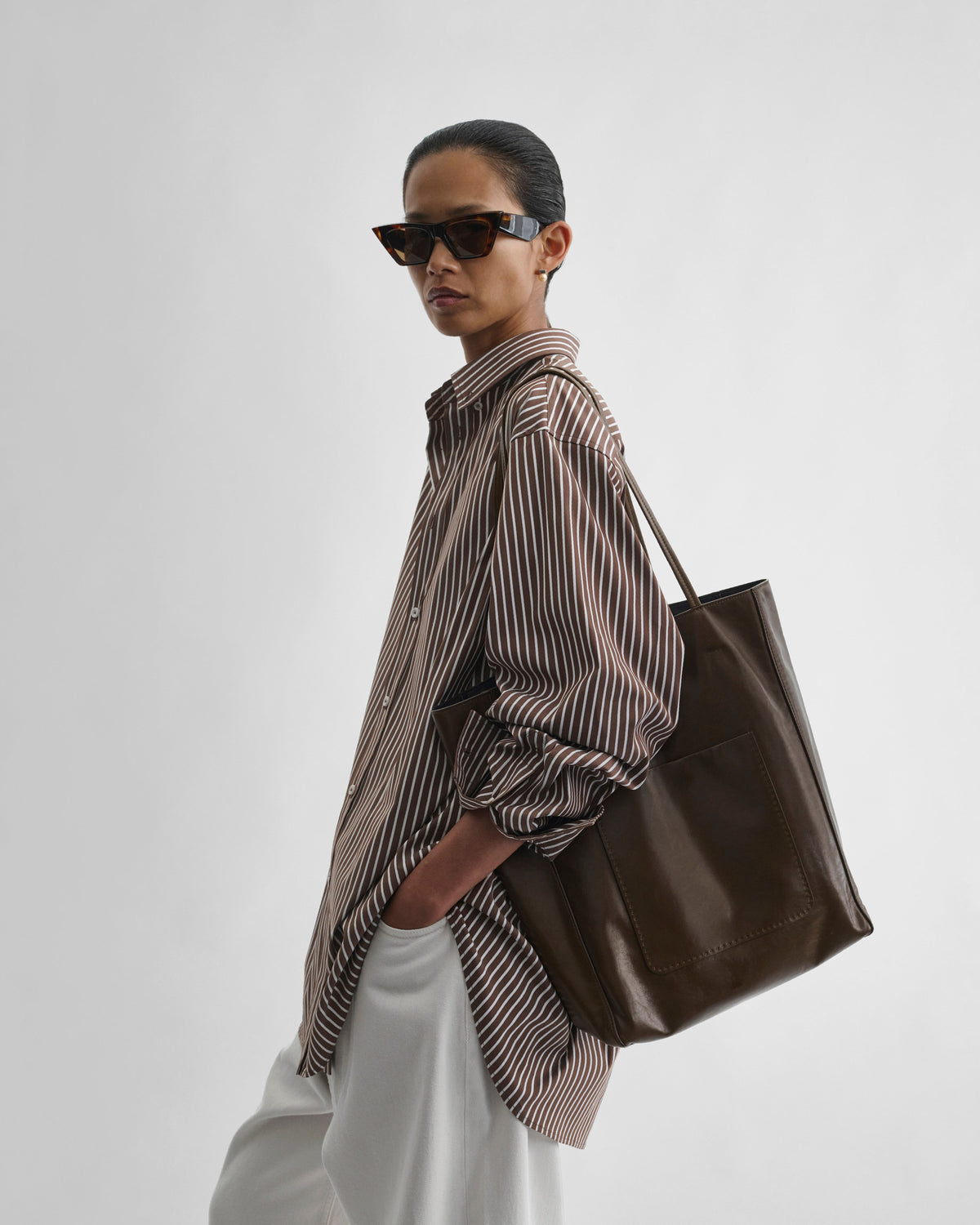 View of model wearing PAPER TOTE in olive leather