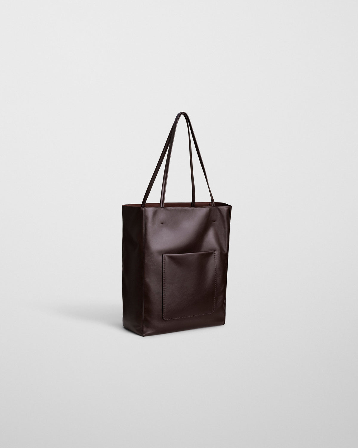 Angled front view of PAPER TOTE in chocolate brown leather