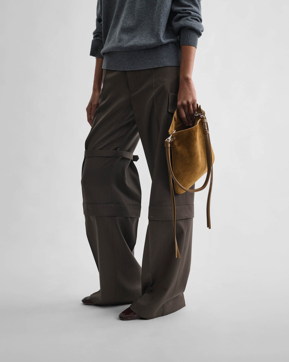 Side view of model wearing GIG POUCH in toffee suede