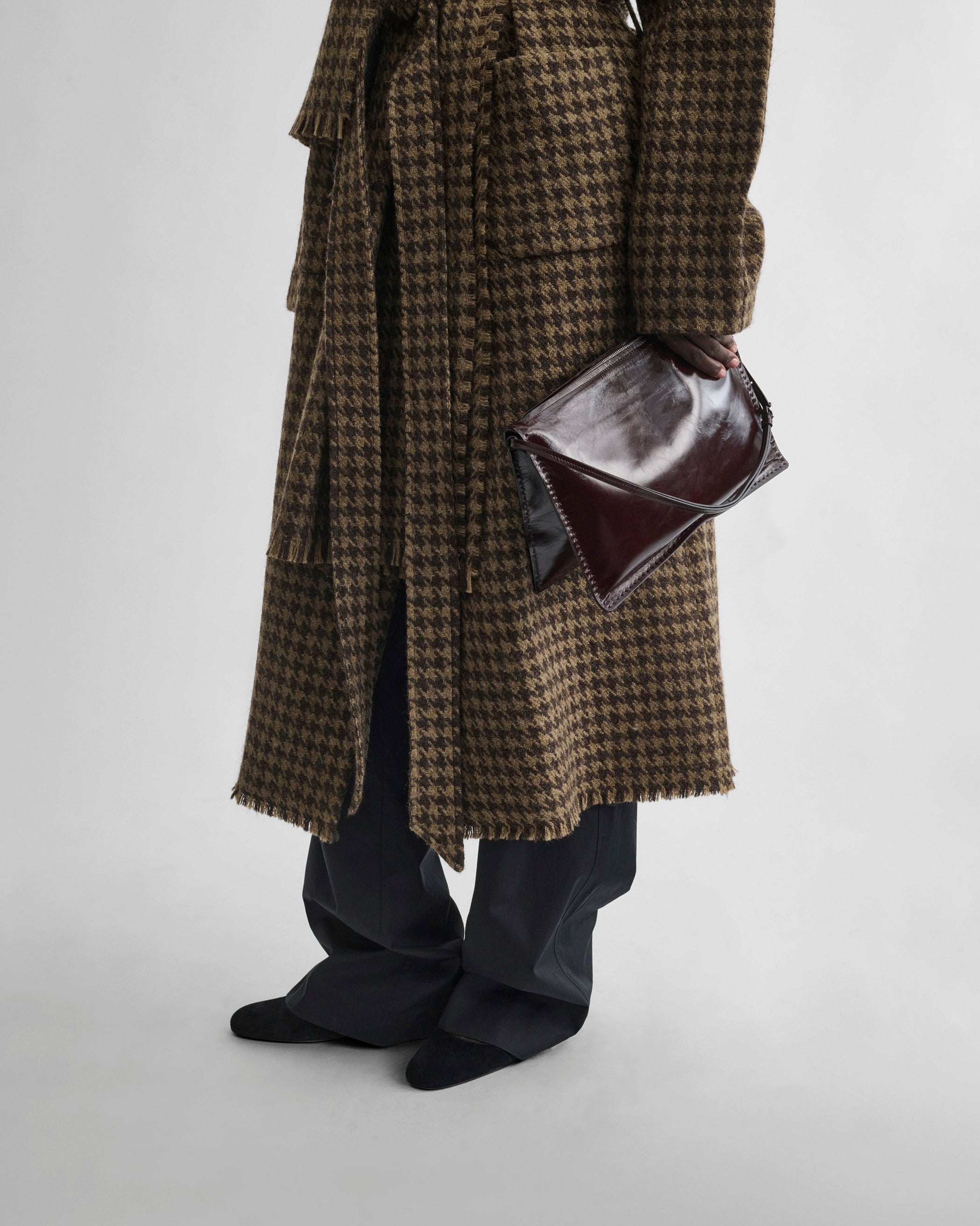 Front view of model holding GLOVE POCHETTE in oxblood leather