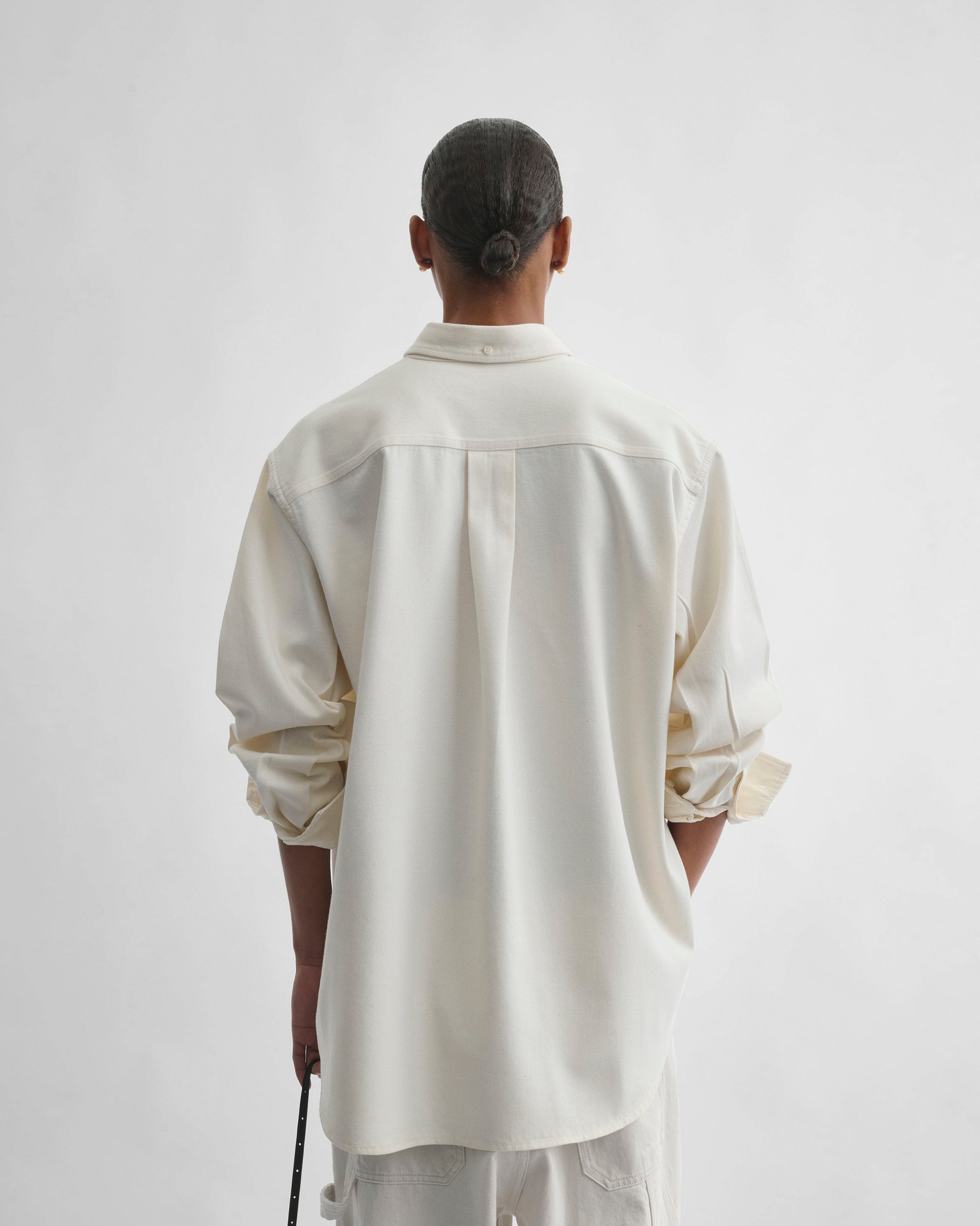 Back view of model wearing DENIM SHIRT in chalk cotton