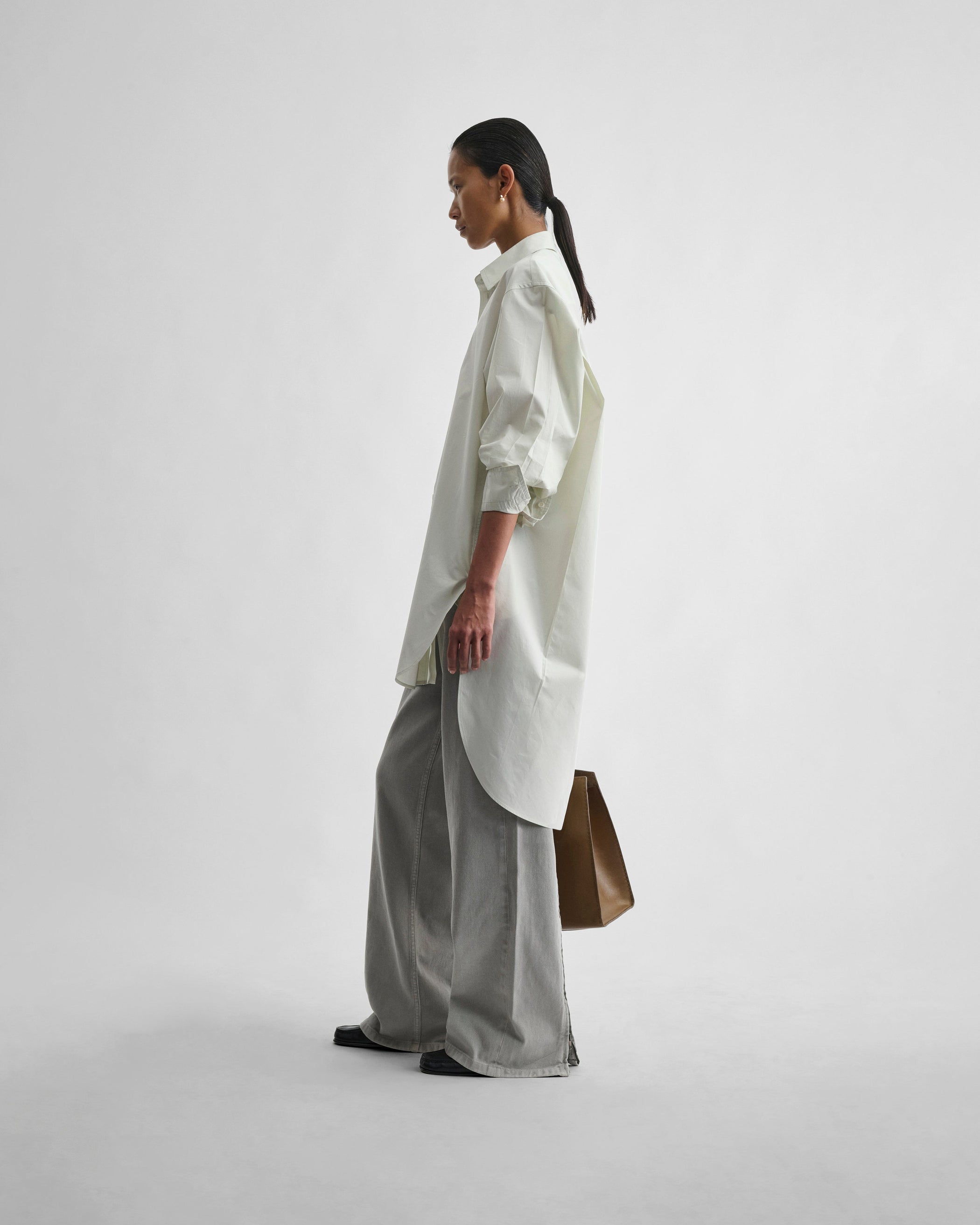 Side view of model wearing ELONGATED SHIRT in soft mint cotton