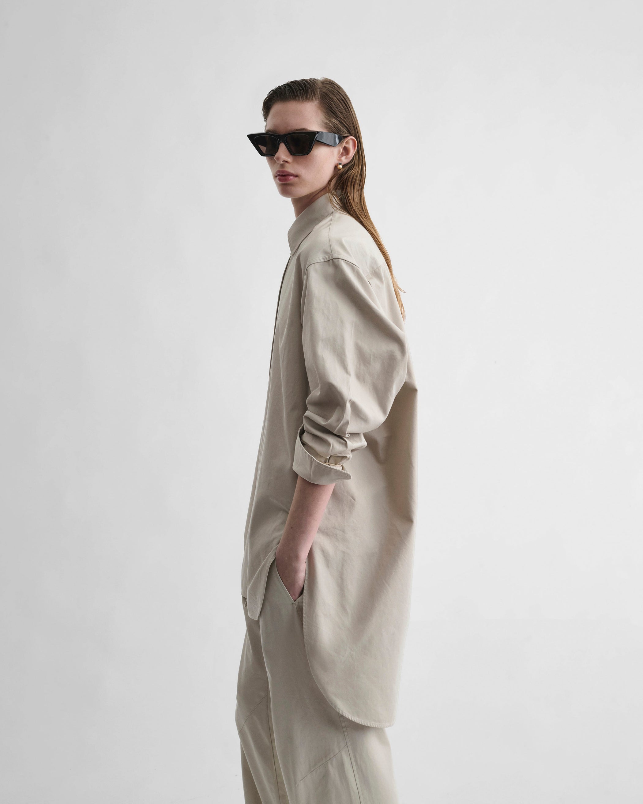 Side view of model wearing ELONGATED SHIRT in cashew cotton