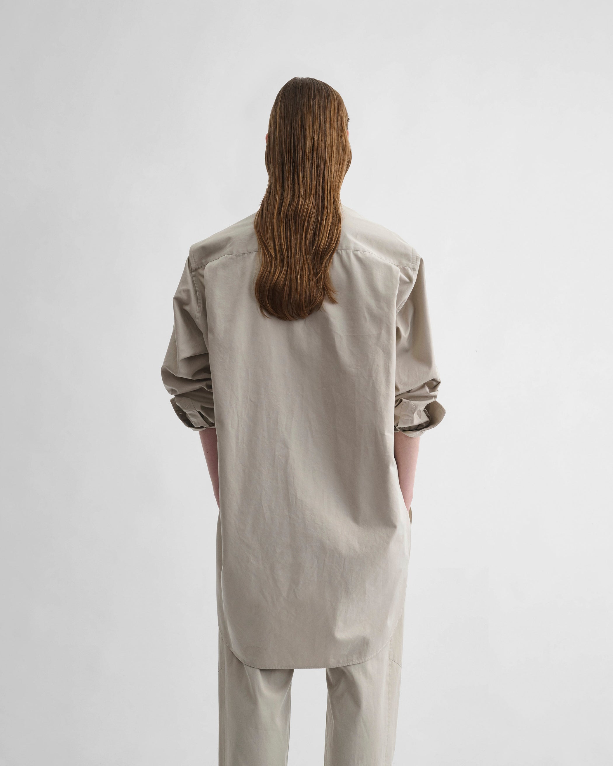 Back view of model wearing ELONGATED SHIRT in cashew cotton