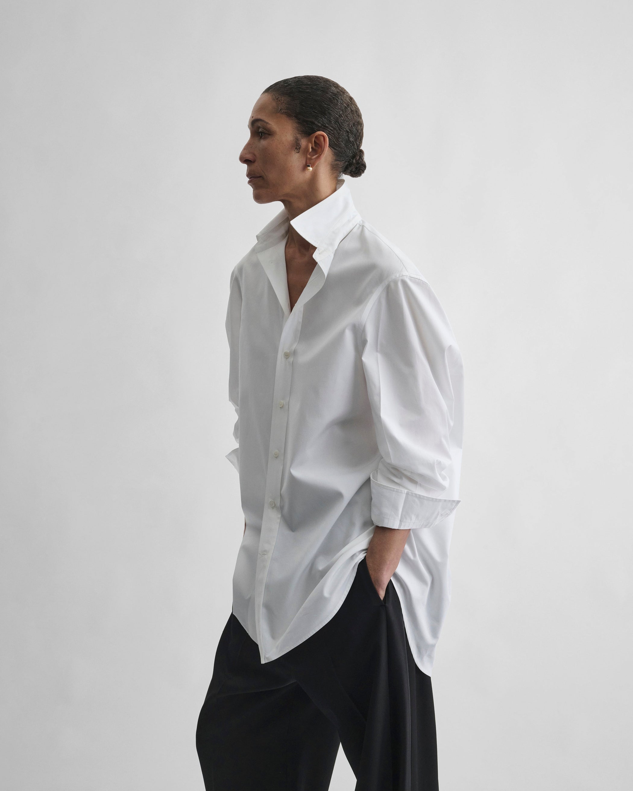 Angled front view of model wearing TUX SHIRT in white cotton