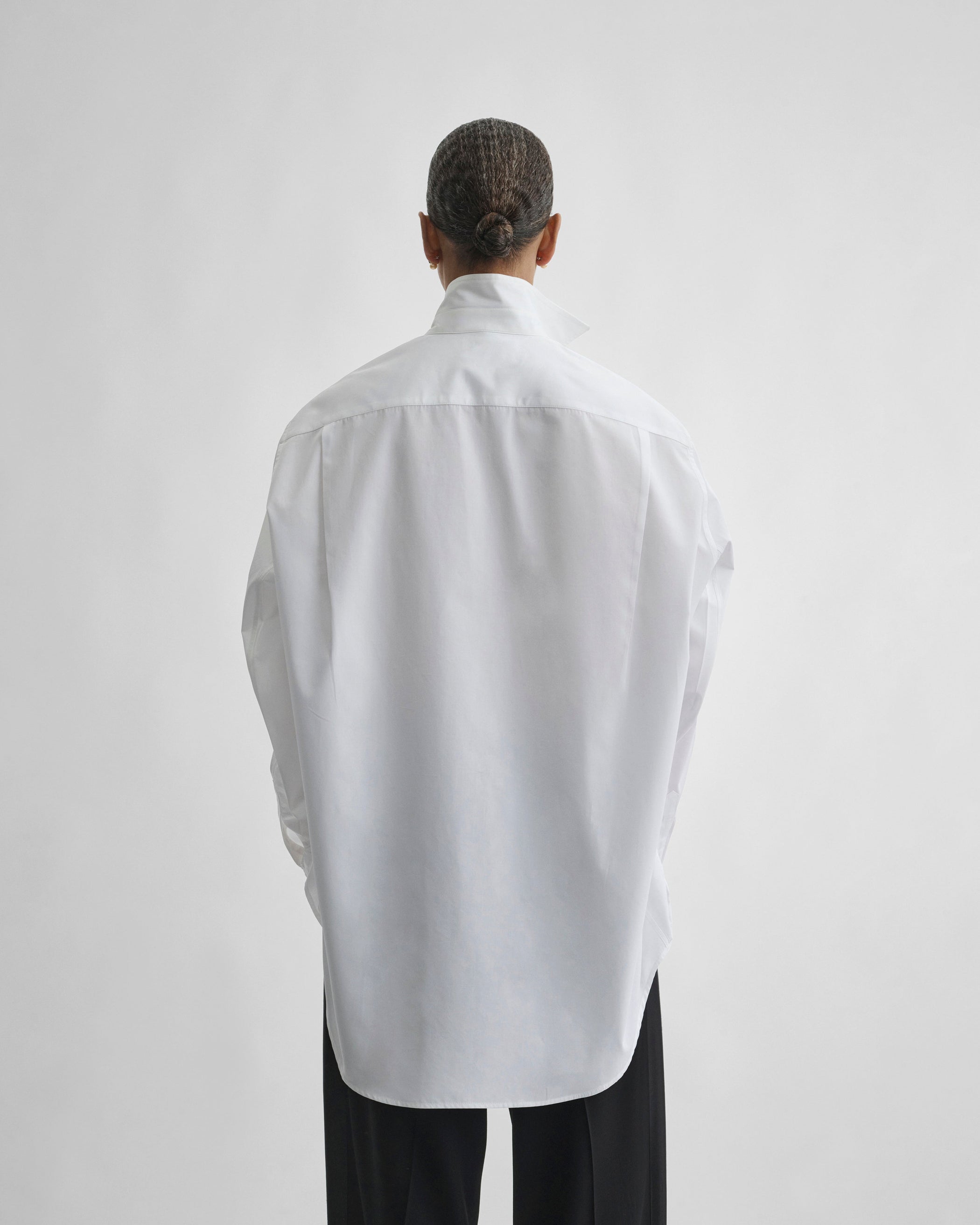 Back view of model wearing TUX SHIRT in white cotton