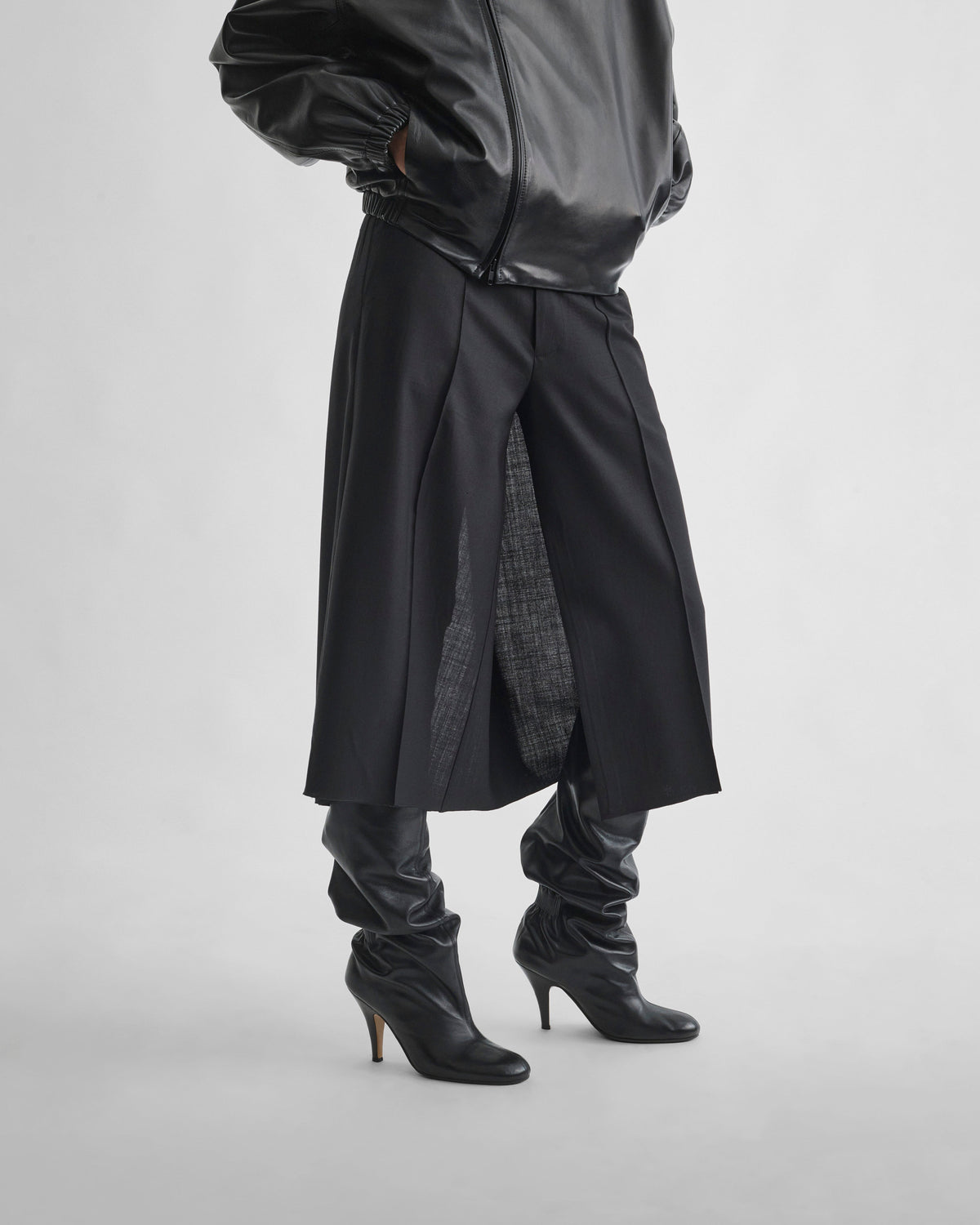 Angled front detail view of model wearing SPLIT SKIRT in black wool
