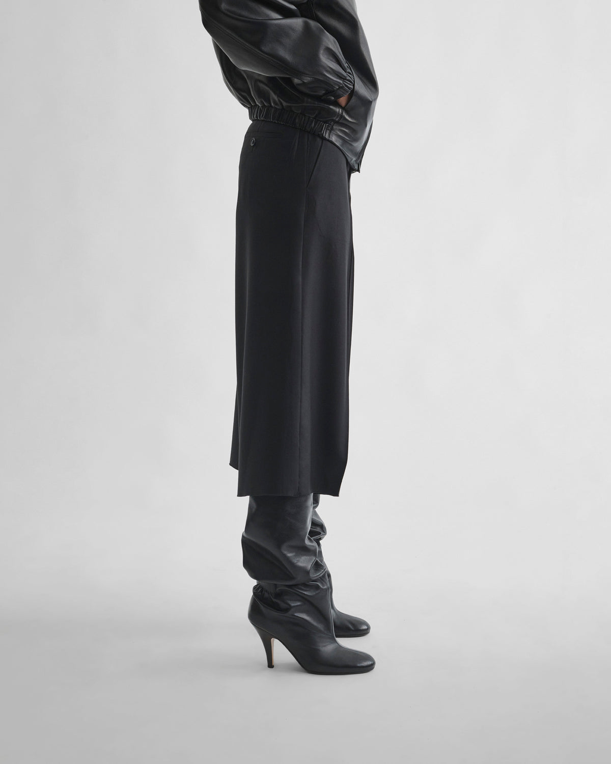 Side view of model wearing SPLIT SKIRT in black wool