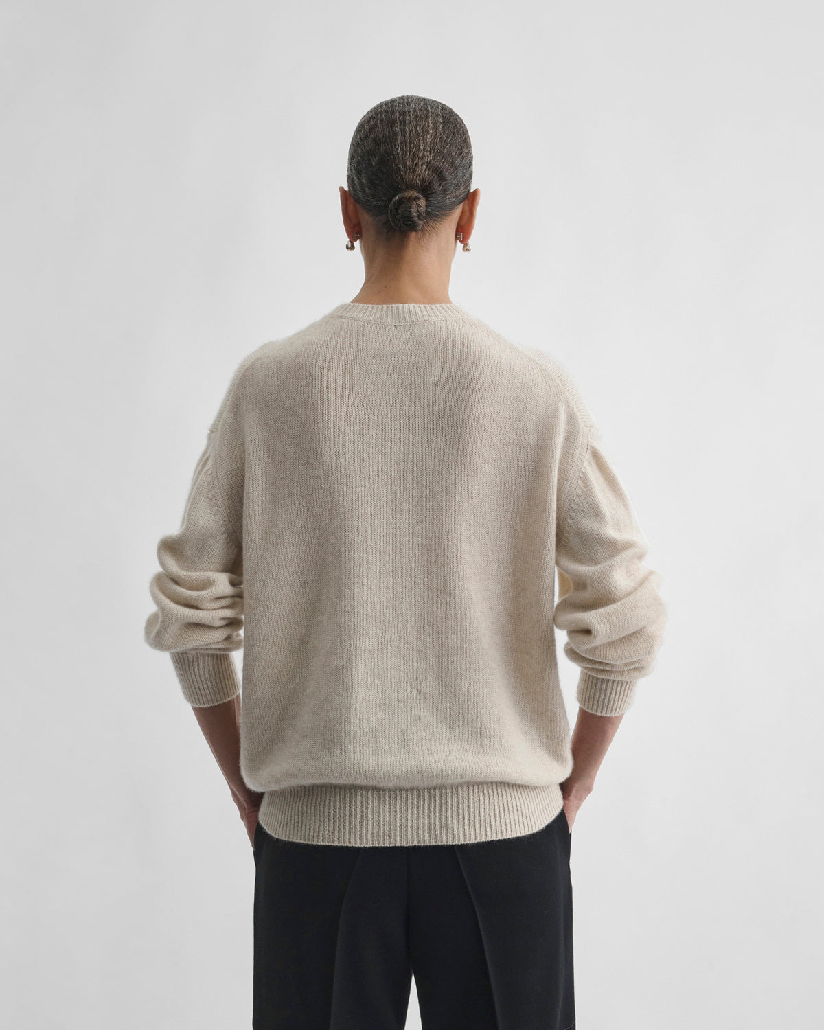 Back view of model wearing CREWNECK SWEATER in cream cashmere