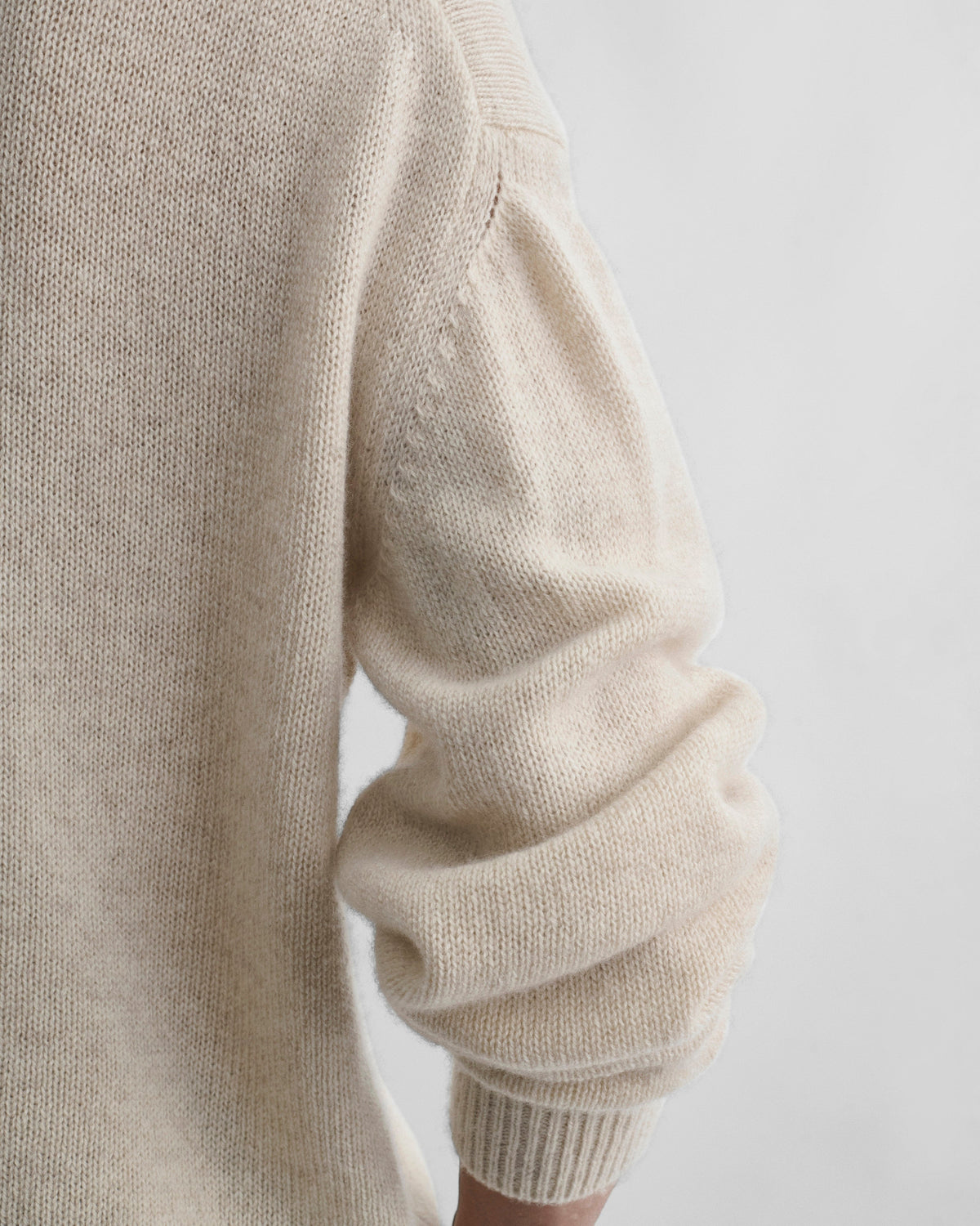 Detail view of model wearing CREWNECK SWEATER in cream cashmere