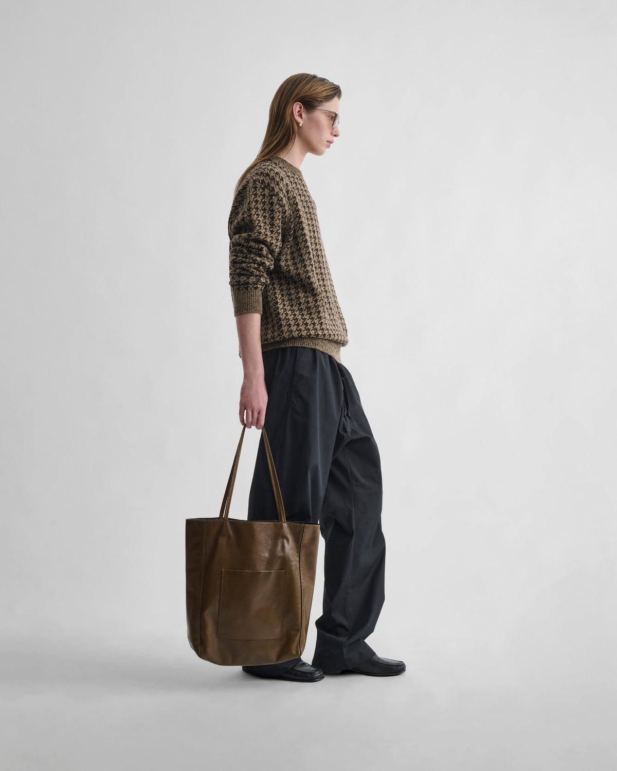 Side view of model wearing CREWNECK JACQUARD SWEATER in brown/beige houndstooth