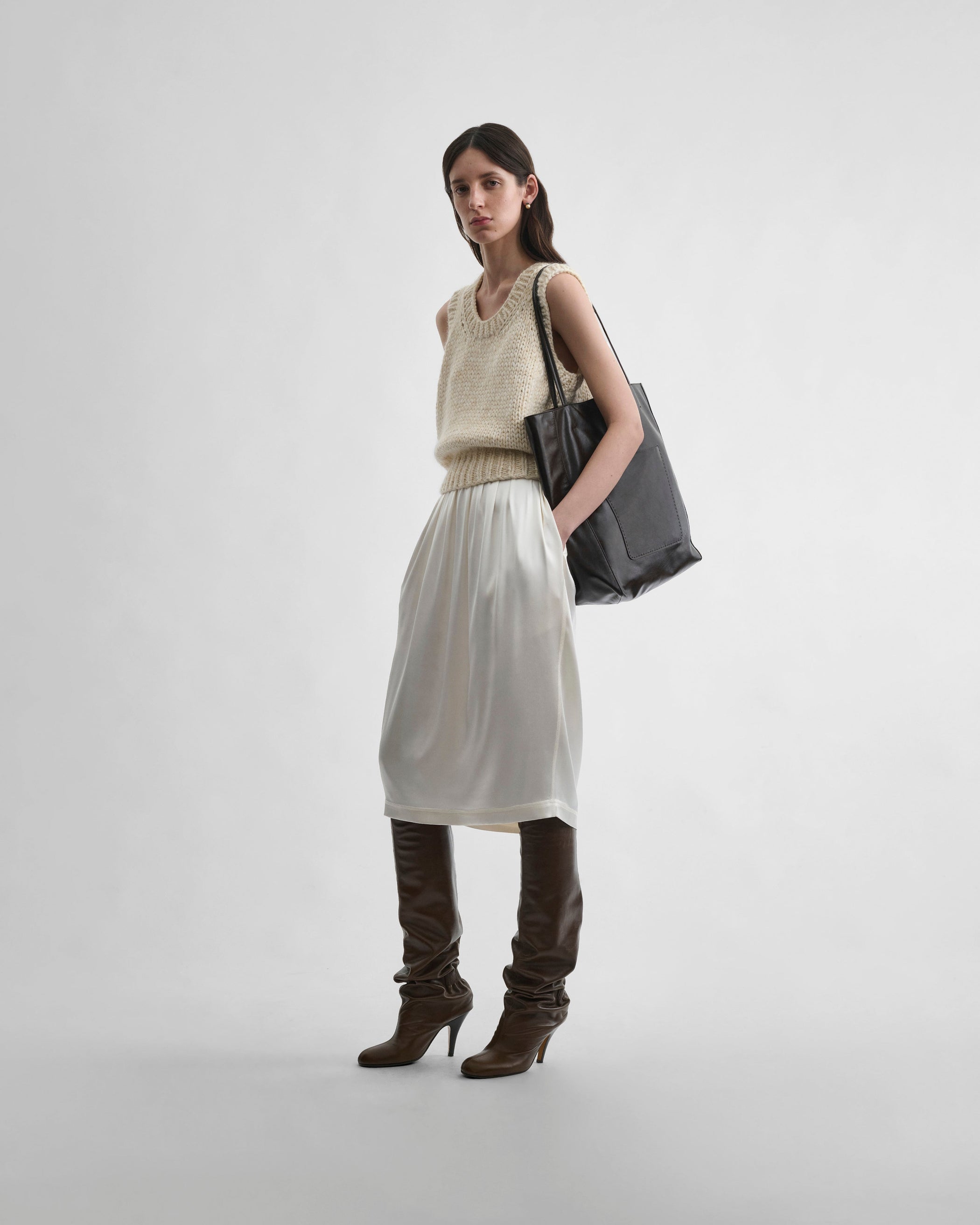 Front view of model wearing HANDKNIT VEST in cream wool