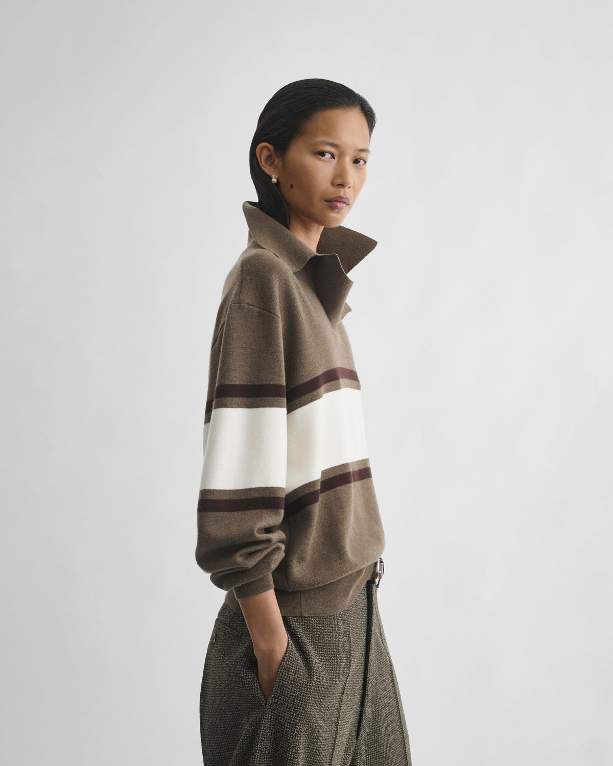 Side view of model wearing OPEN POLO SWEATER in cigar/cream/chocolate brown wool
