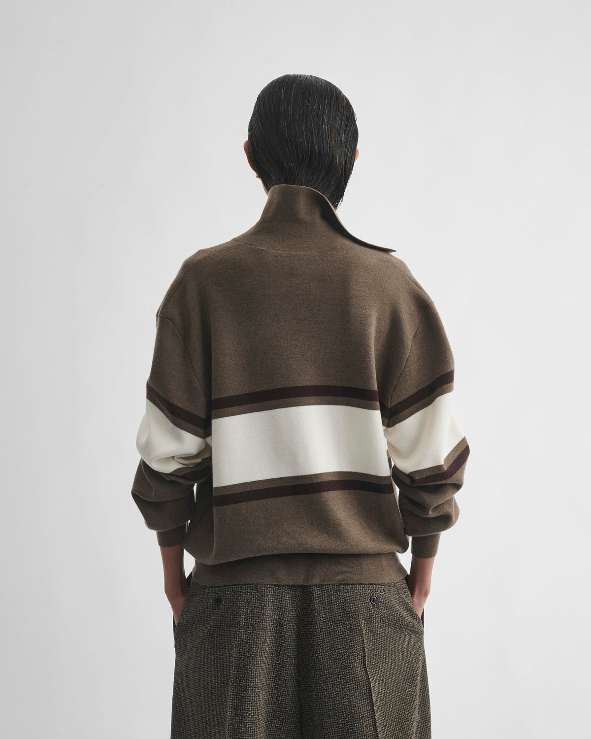 Back view of model wearing OPEN POLO SWEATER in cigar/cream/chocolate brown wool