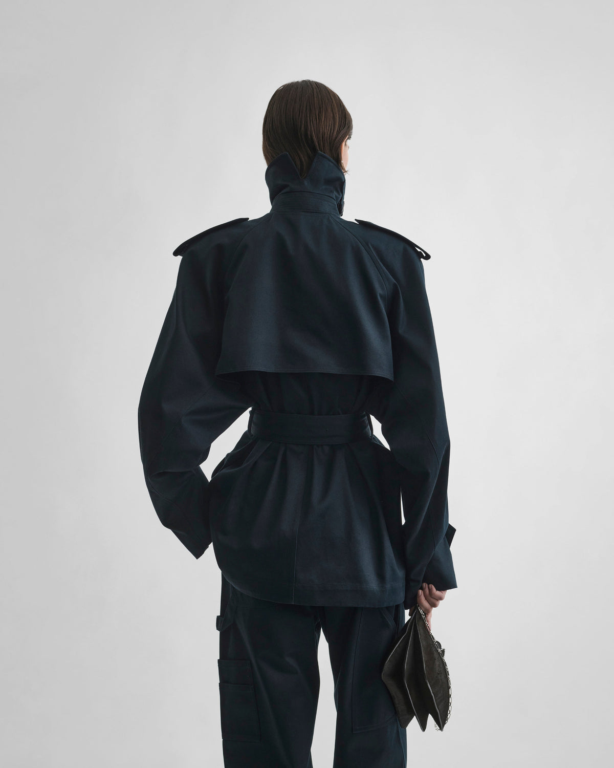 Back view of model wearing CROPPED TRENCH in black ink cotton