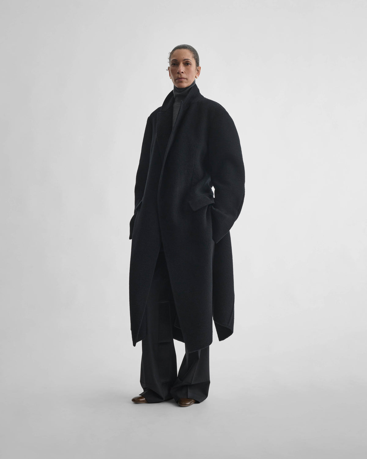 Angled front view of model wearing BELTED ROBE COAT in black cashmere
