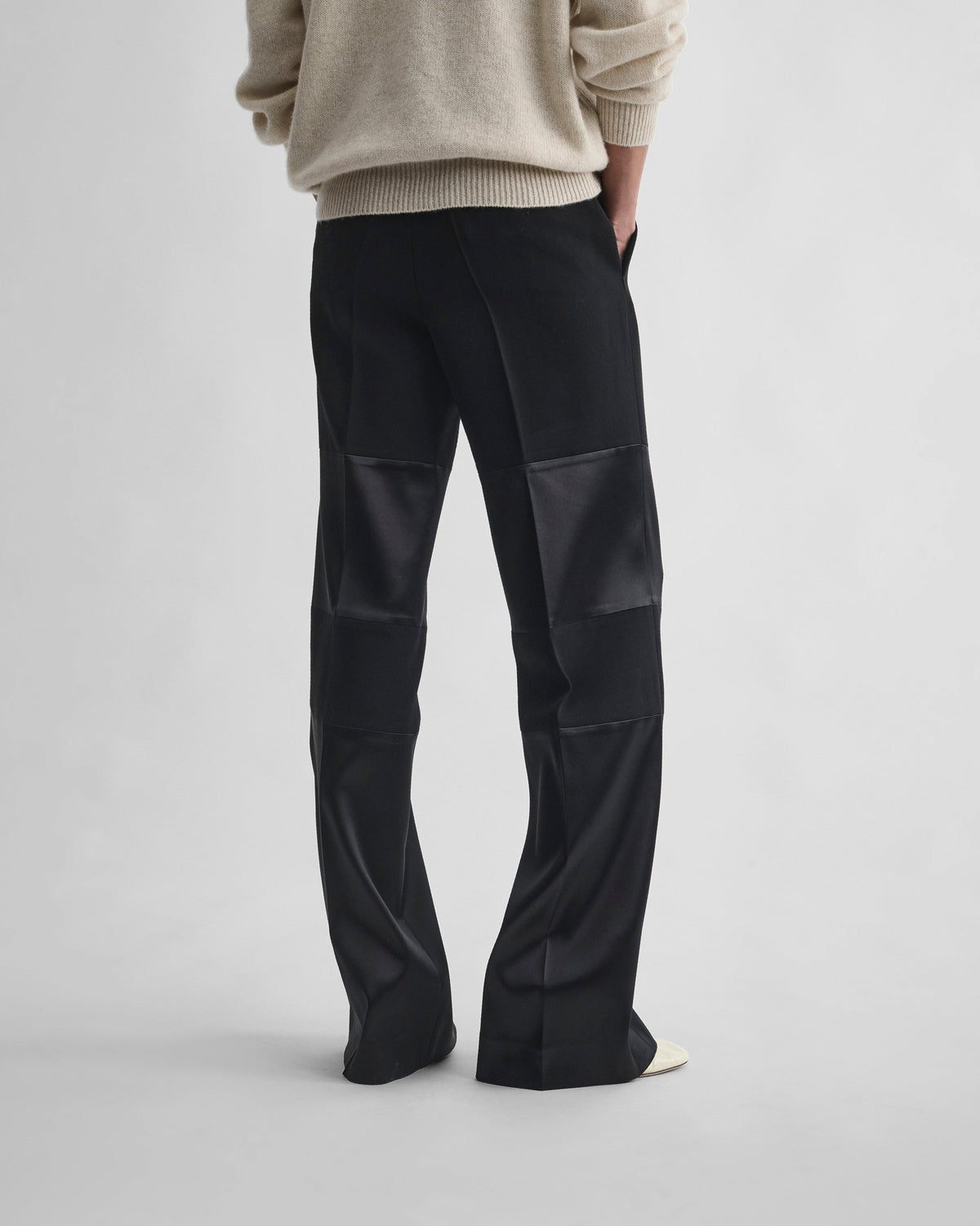 Back view of model wearing STACKED TUX TROUSERS in black wool