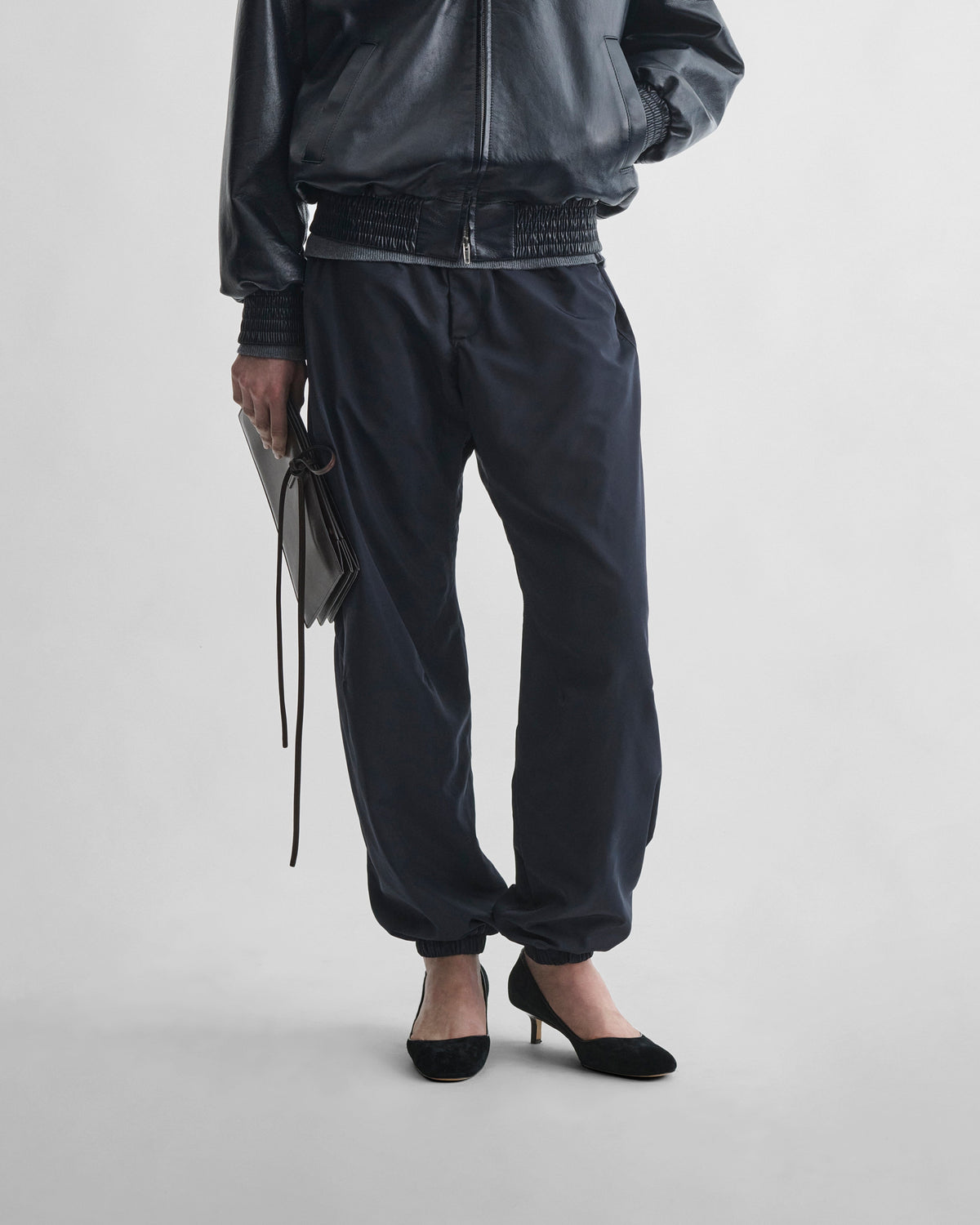 Front view of model wearing CUFFED JOGGERS in dark navy nylon