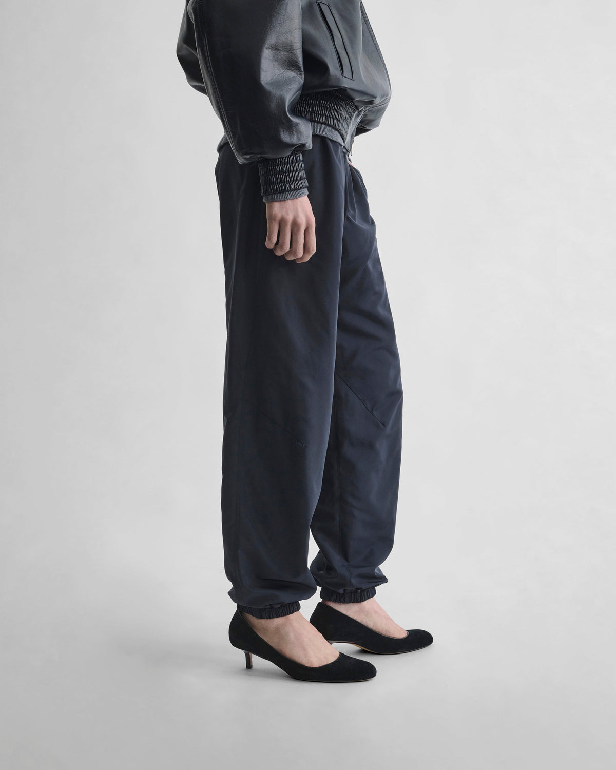 Side view of model wearing CUFFED JOGGERS in dark navy nylon