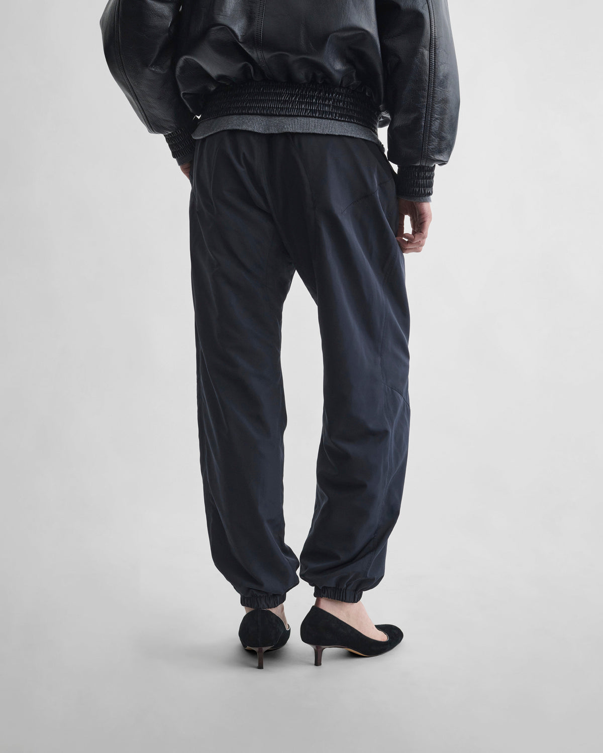 Back view of model wearing CUFFED JOGGERS in dark navy nylon