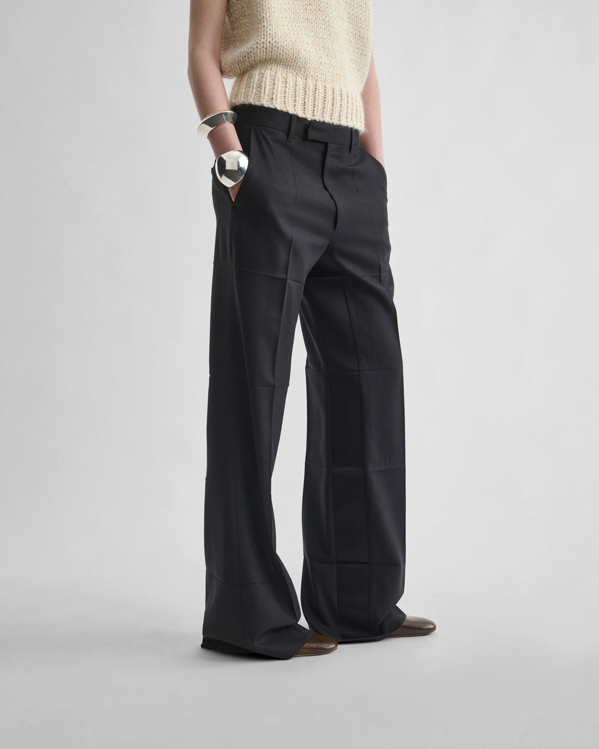 Angled front view of model wearing TUX BOYISH TROUSERS in black wool
