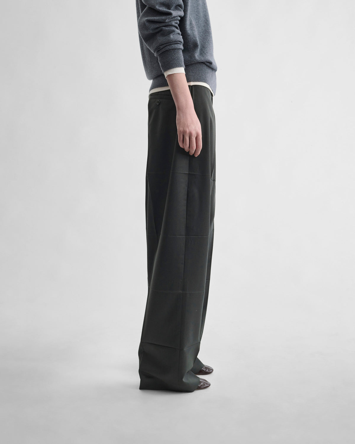 Side view of model wearing PRESSED DROP TROUSERS in green bronze wool