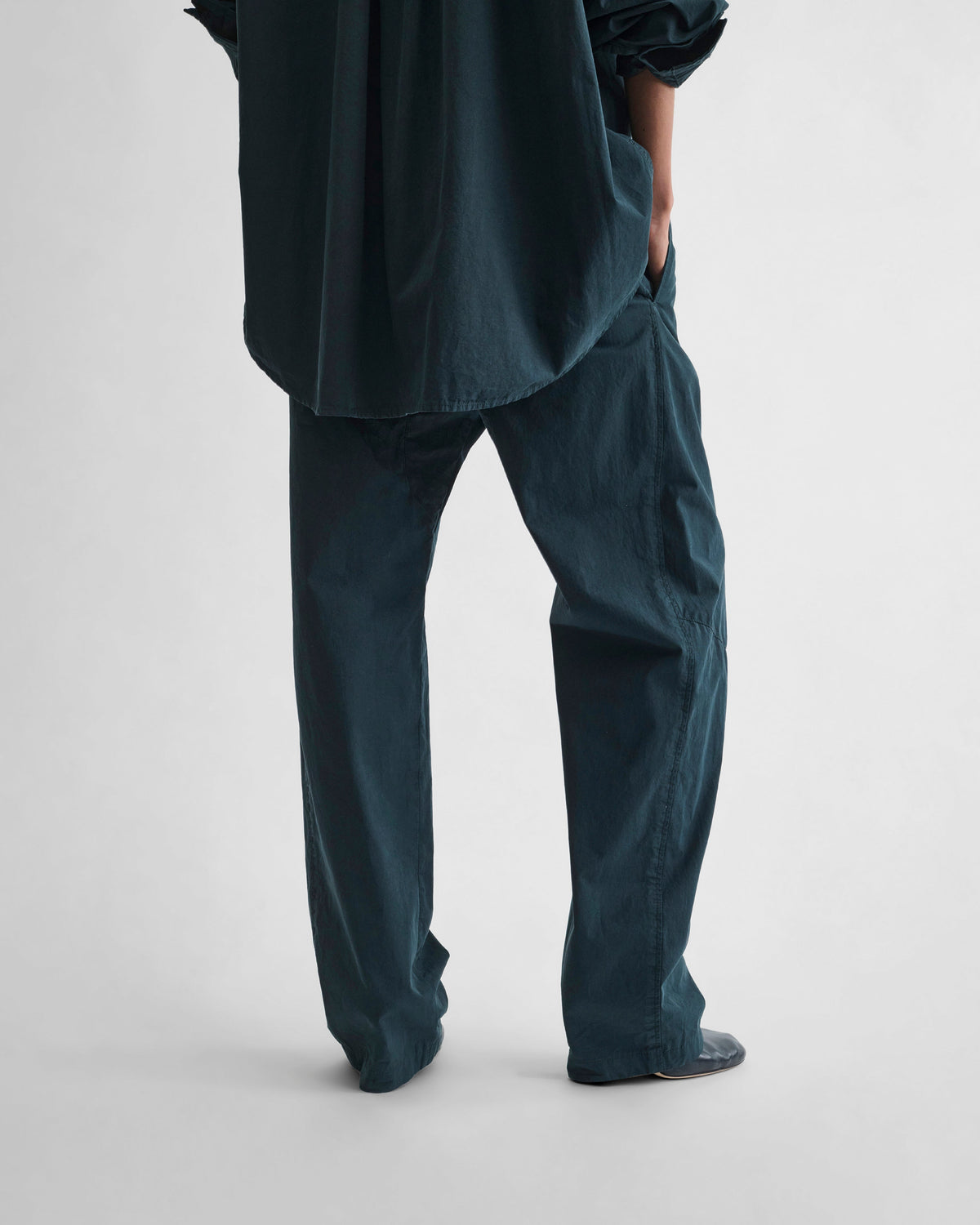 Back view of model wearing ARCH TROUSERS in black ink cotton