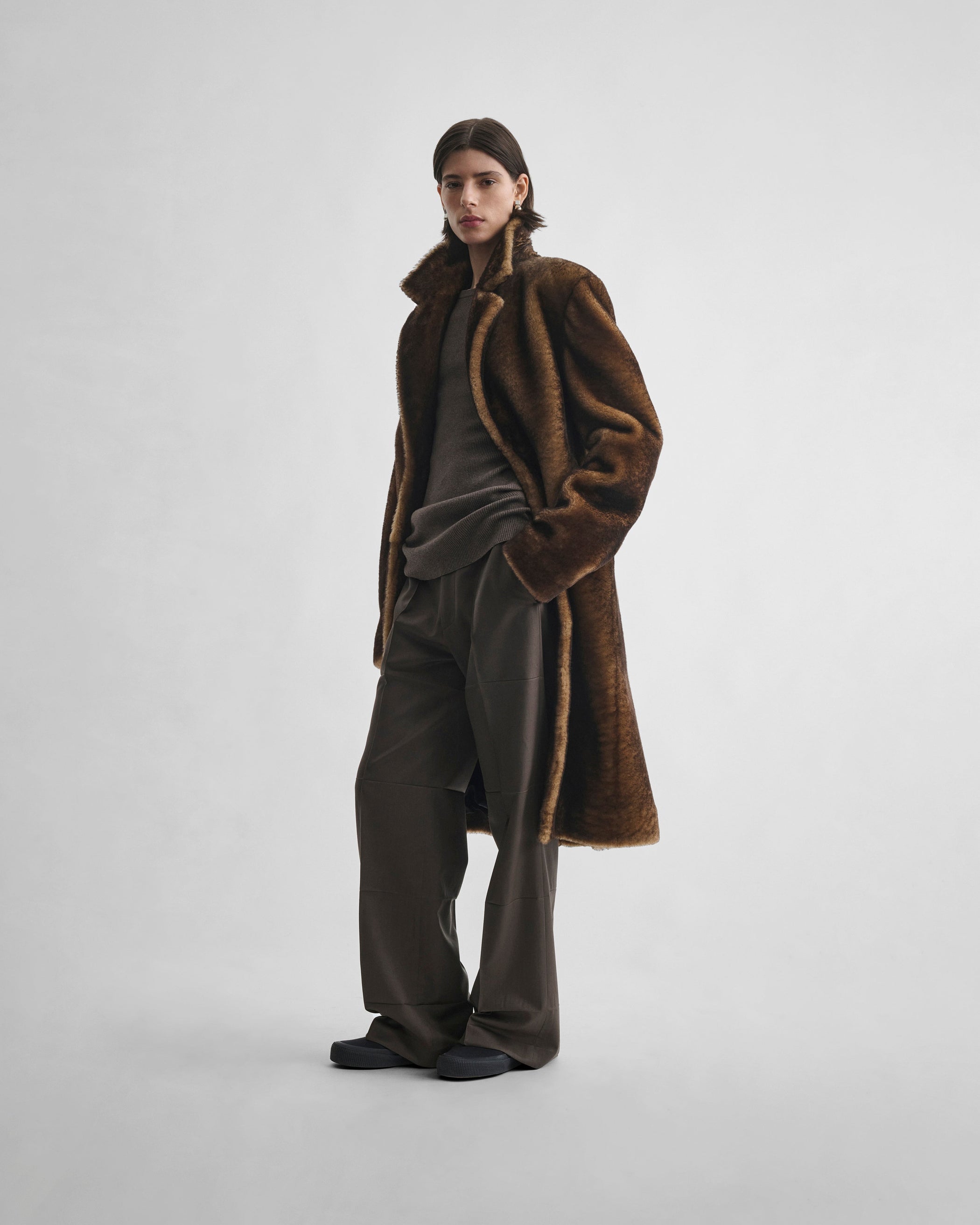 Side view of model wearing CREASED BOYISH TAILORED TROUSERS in brown khaki wool