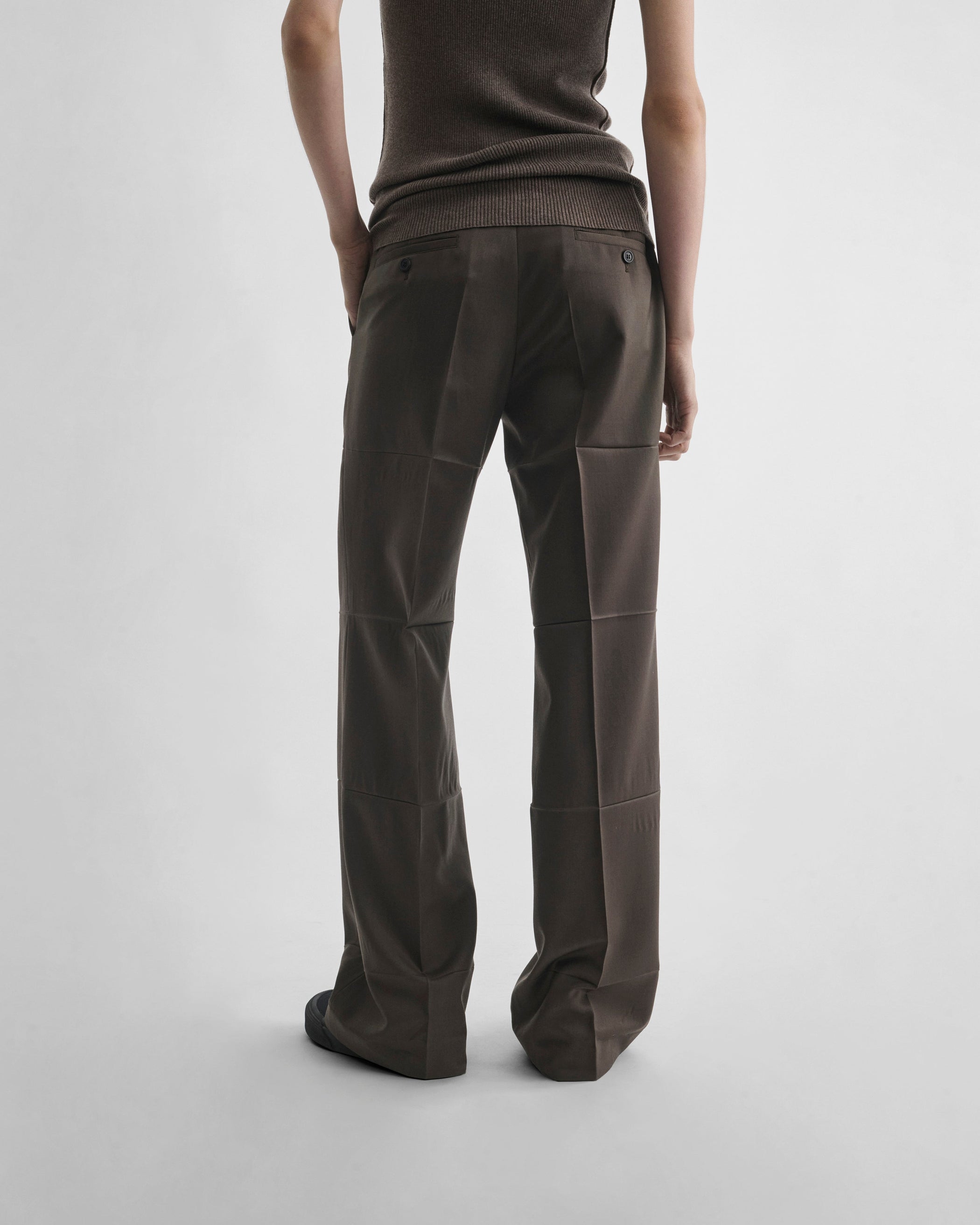 Back view of model wearing CREASED BOYISH TAILORED TROUSERS in brown khaki wool