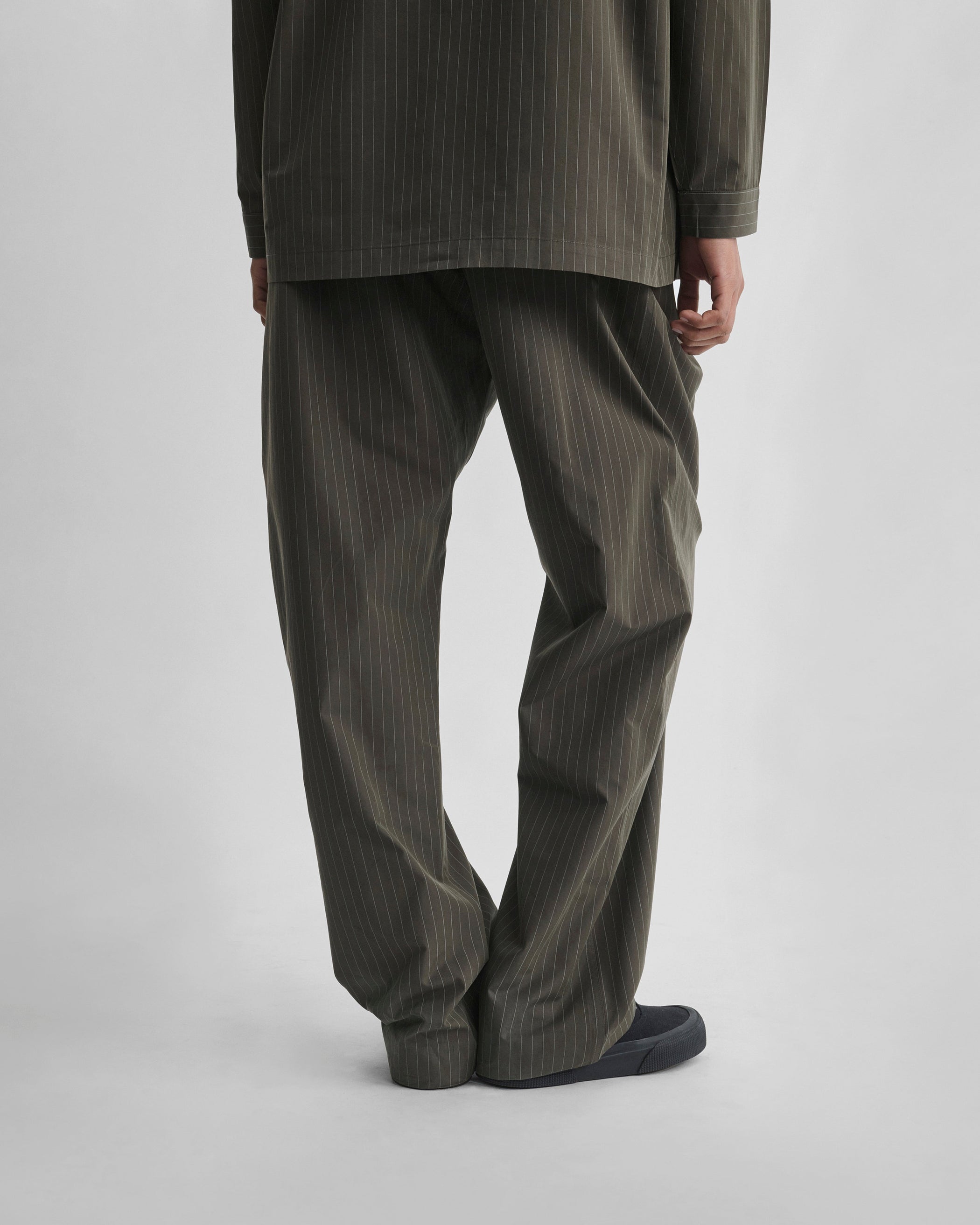 Back view of model wearing PYJAMA TROUSERS in dark khaki cotton