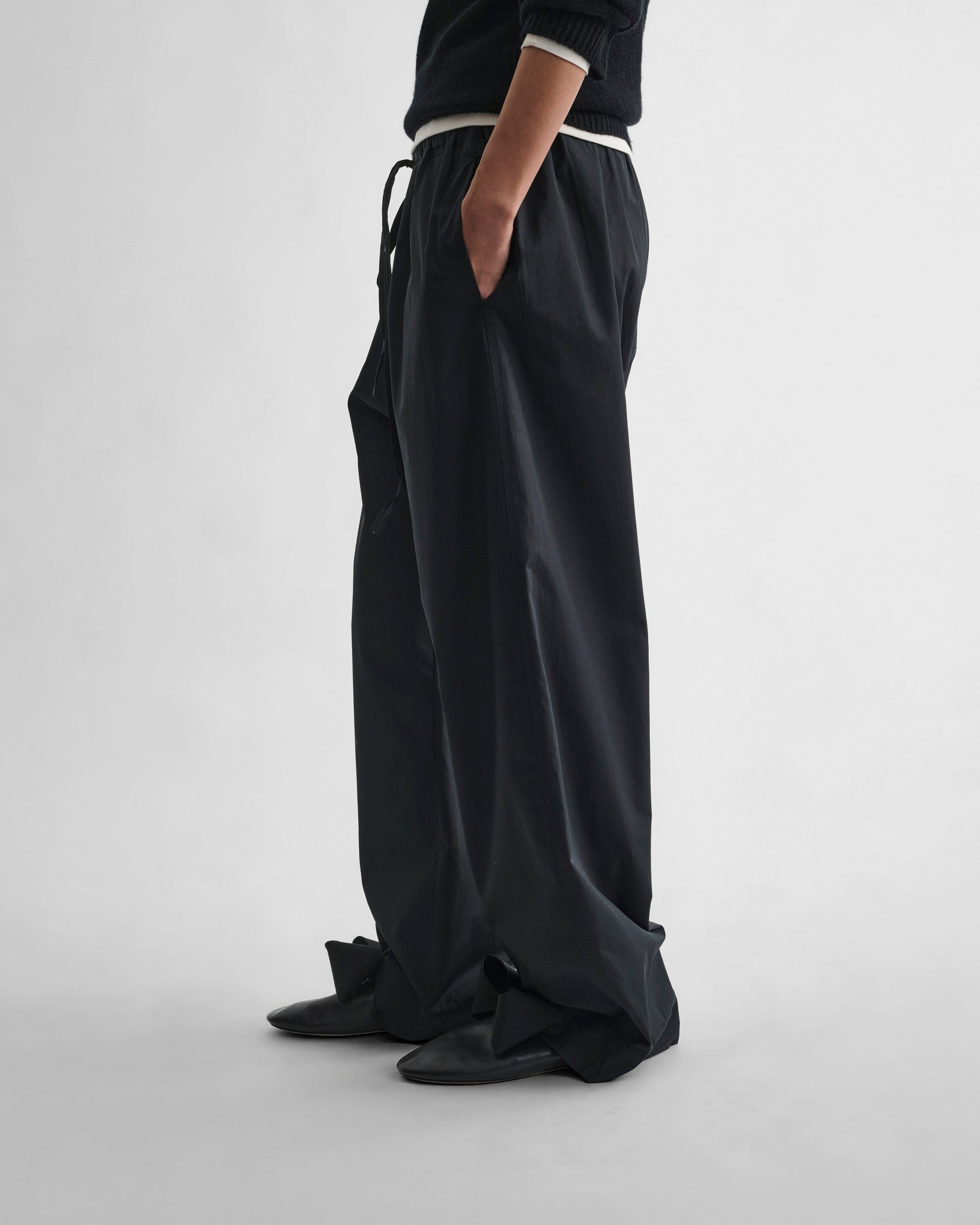 Side view of model wearing PYJAMA TROUSERS in black cotton