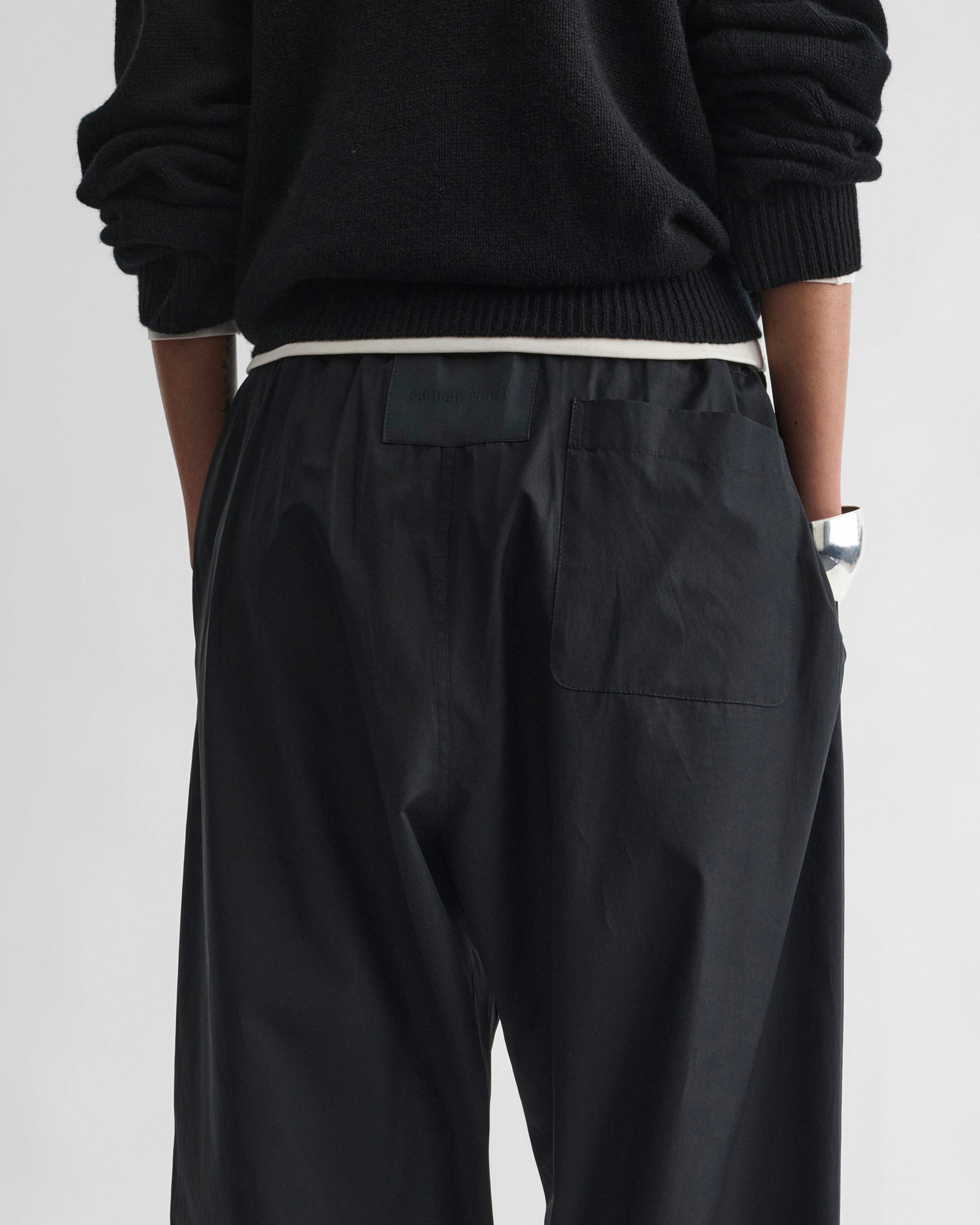 Back view of model wearing PYJAMA TROUSERS in black cotton