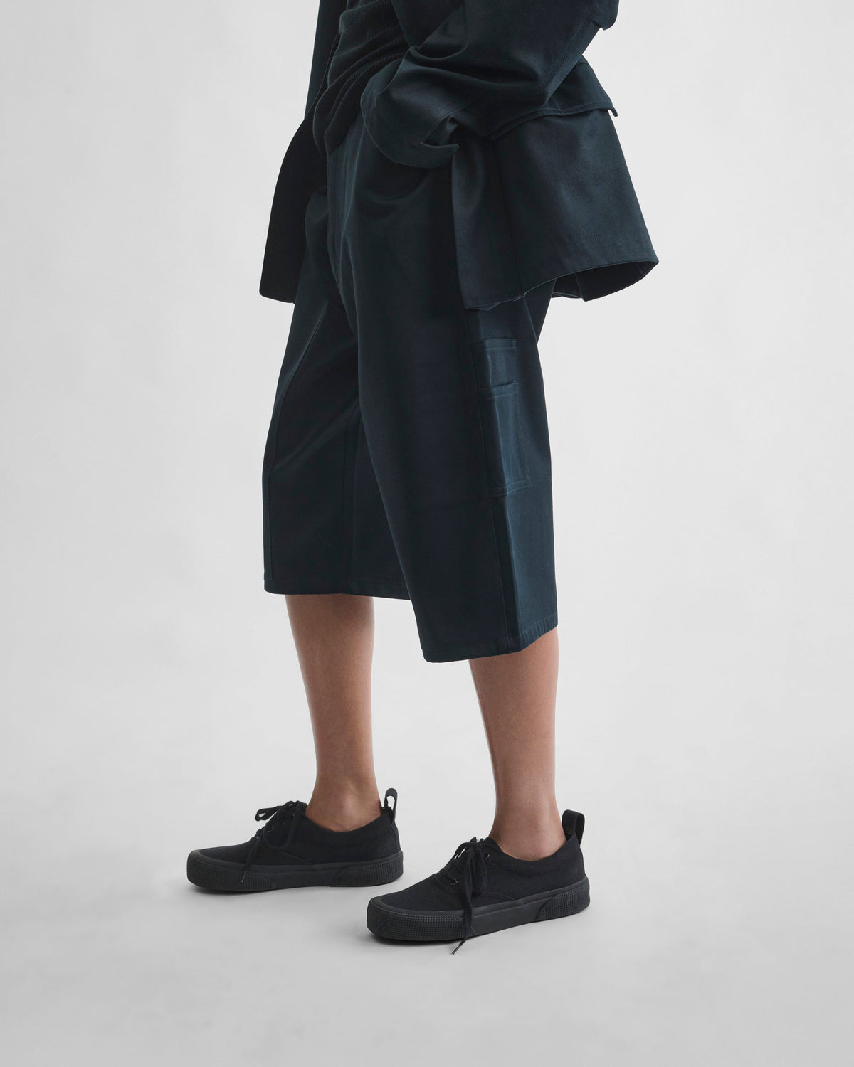Side view of model wearing UTILITY SHORTS in black ink cotton