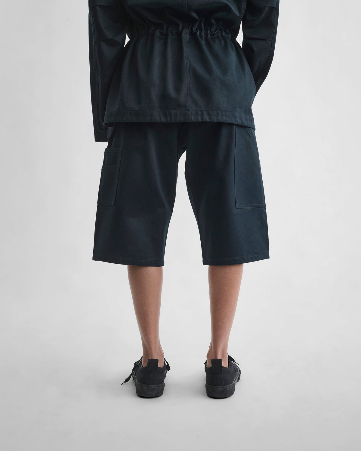 Back view of model wearing UTILITY SHORTS in black ink cotton