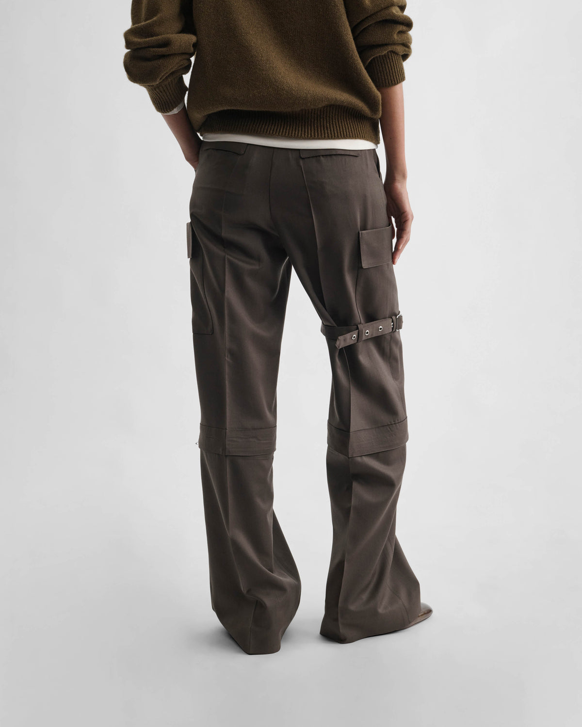 Back view of model wearing STRAP TROUSERS in brown khaki wool