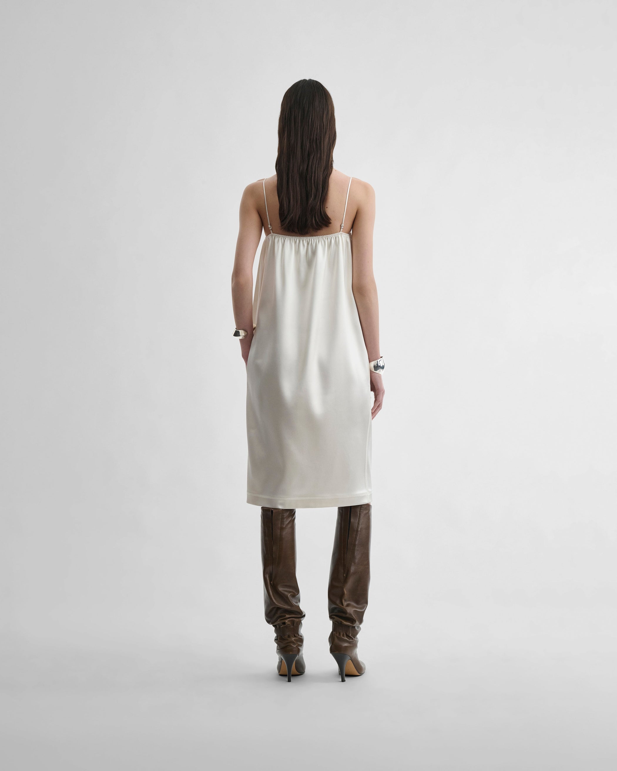 Back view of model wearing LIQUID SLIP DRESS in acid ivory silk