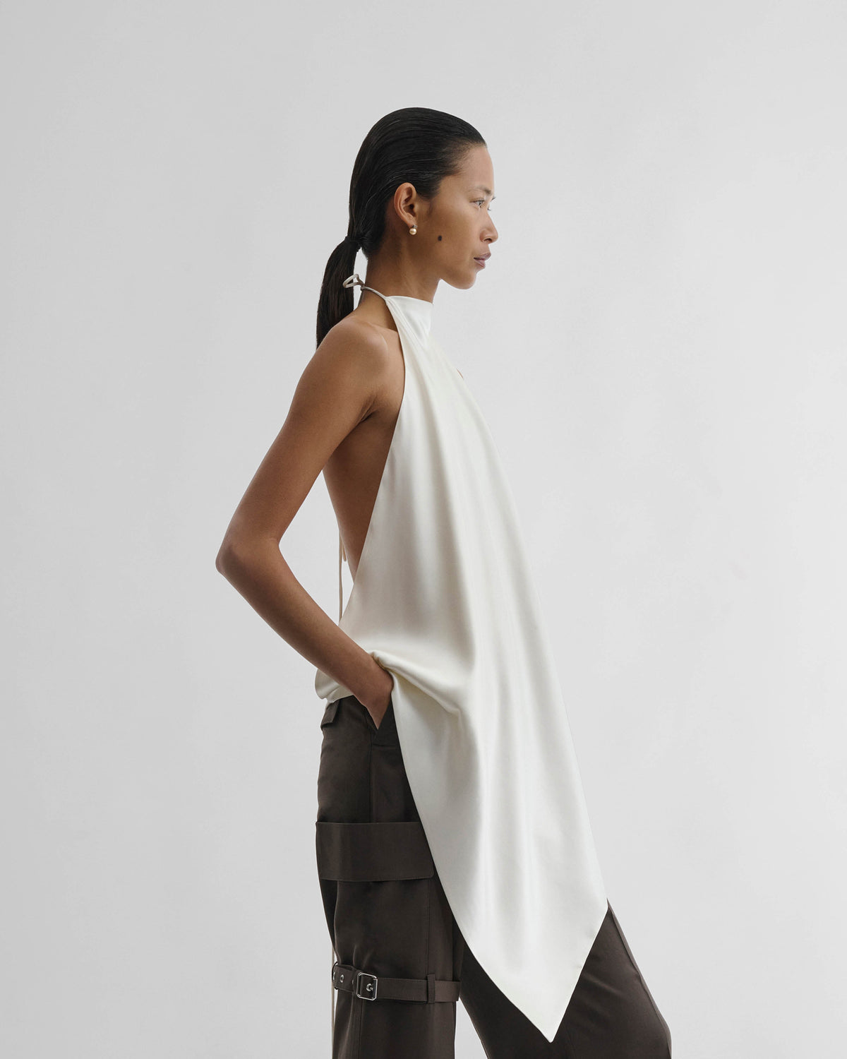 Side view of model wearing LIQUID SCARF TOP in cream silk