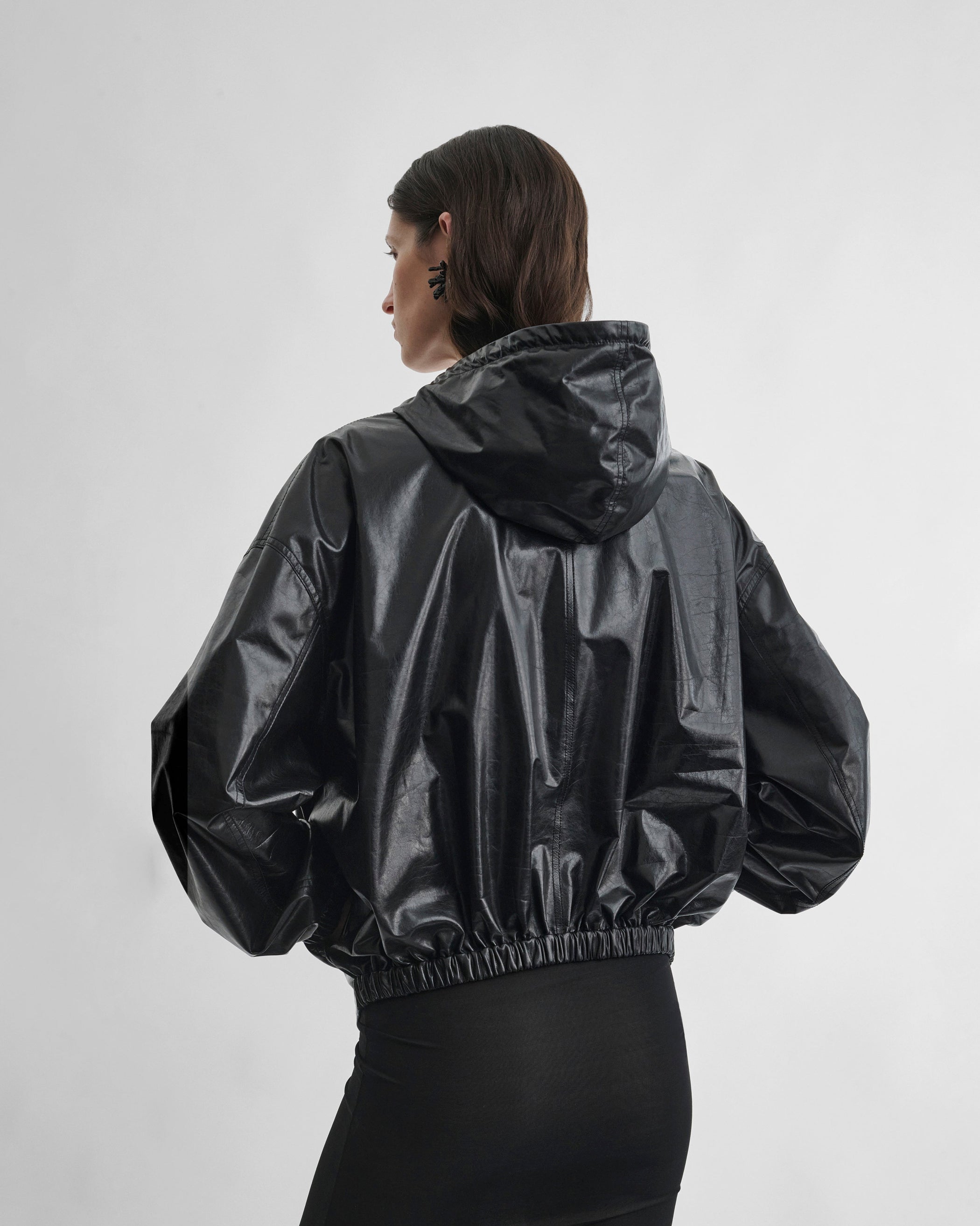 Back view of model wearing ANORAK in black leather