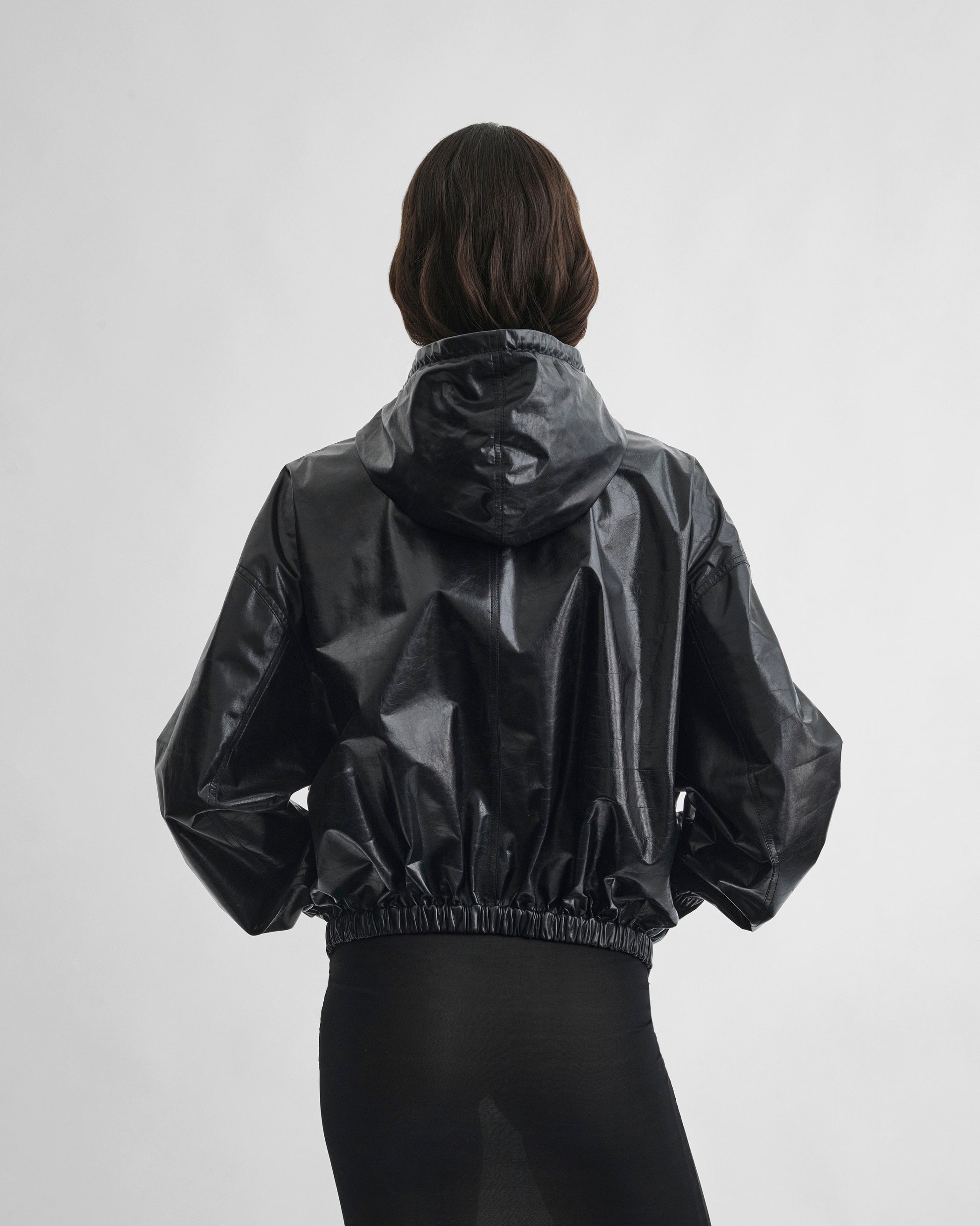 Back view of model wearing ANORAK in black leather