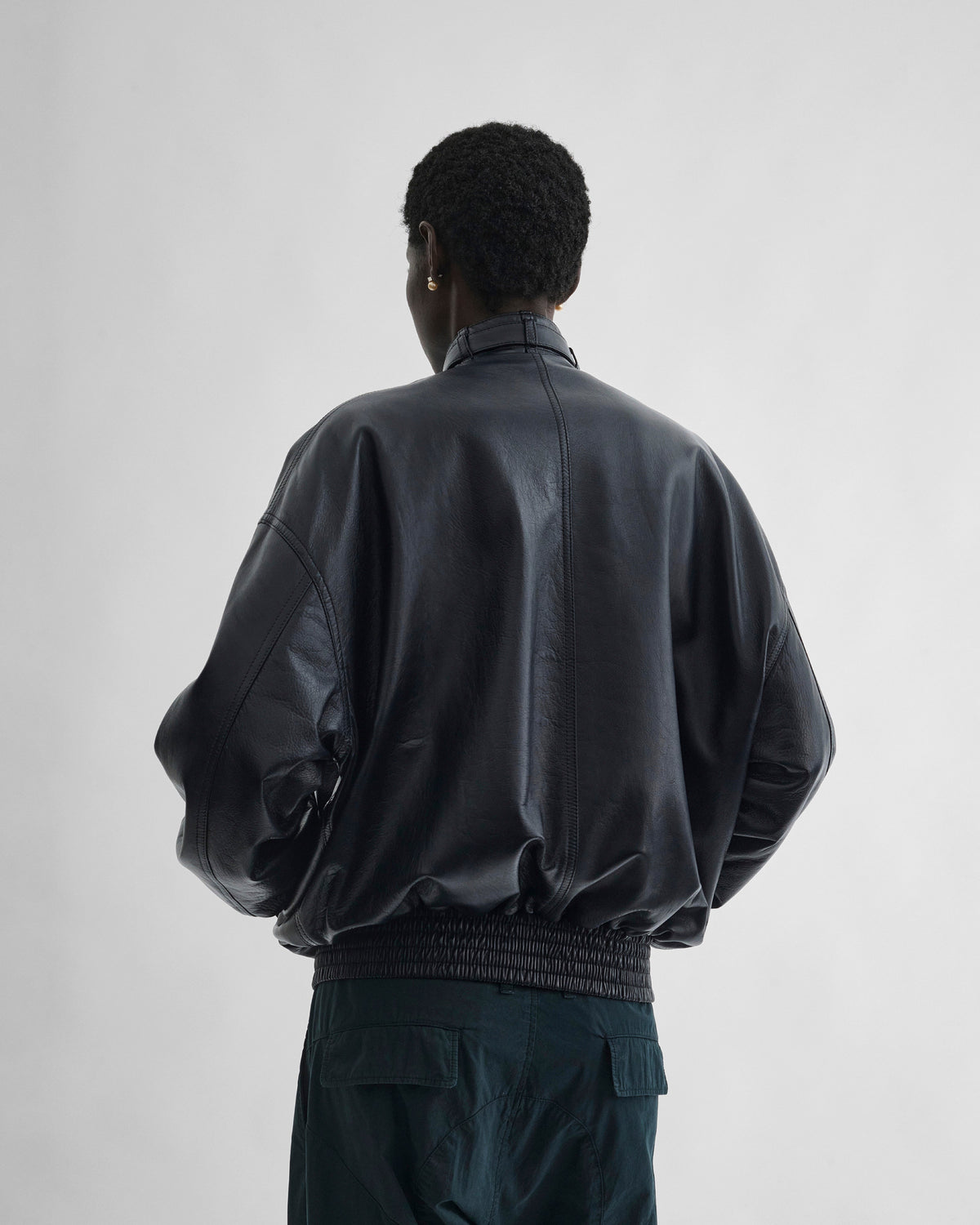 Back view of model wearing CLASSIC BOMBER in black ink leather