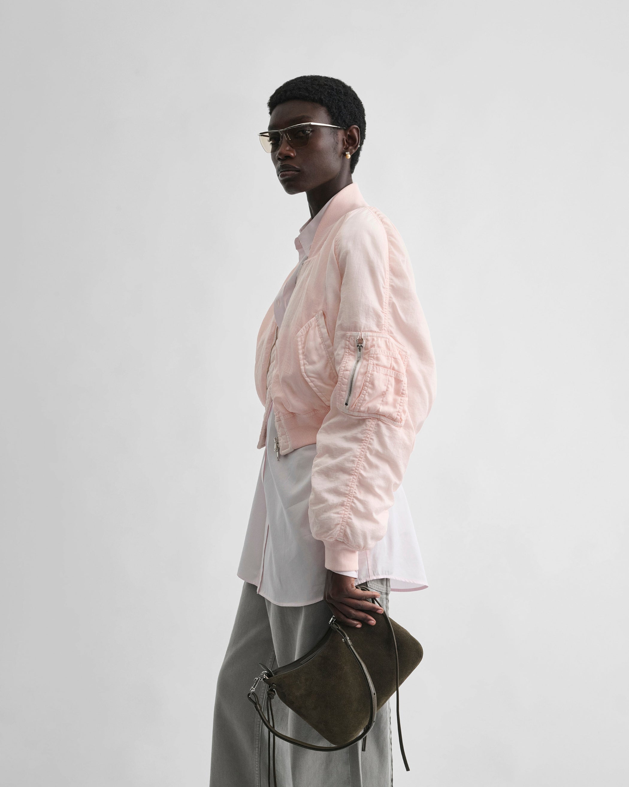 Side view of model wearing WASHED BOMBER in pale pink nylon