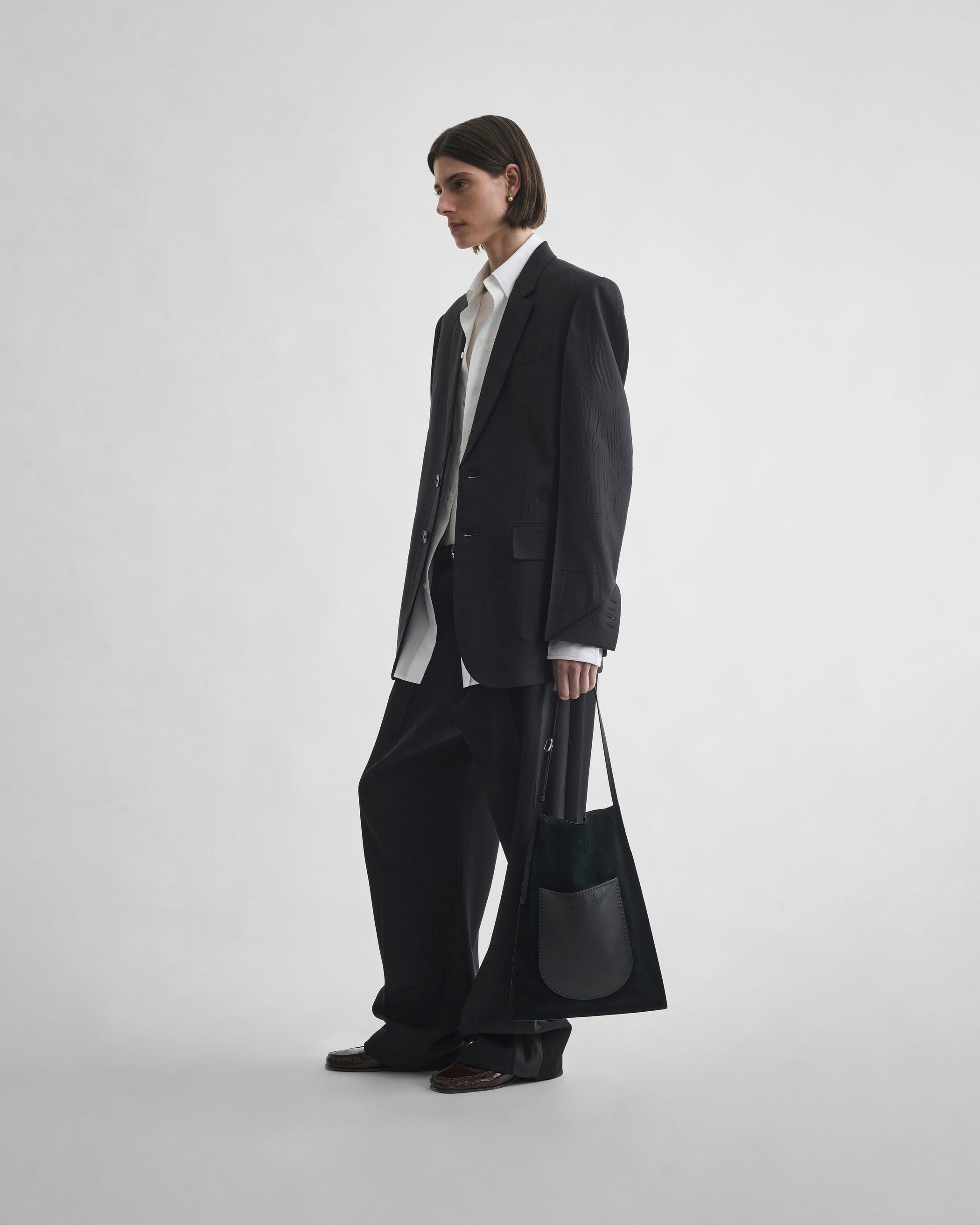 Angled front view of model wearing NEAPOLITAN JACKET in black wool