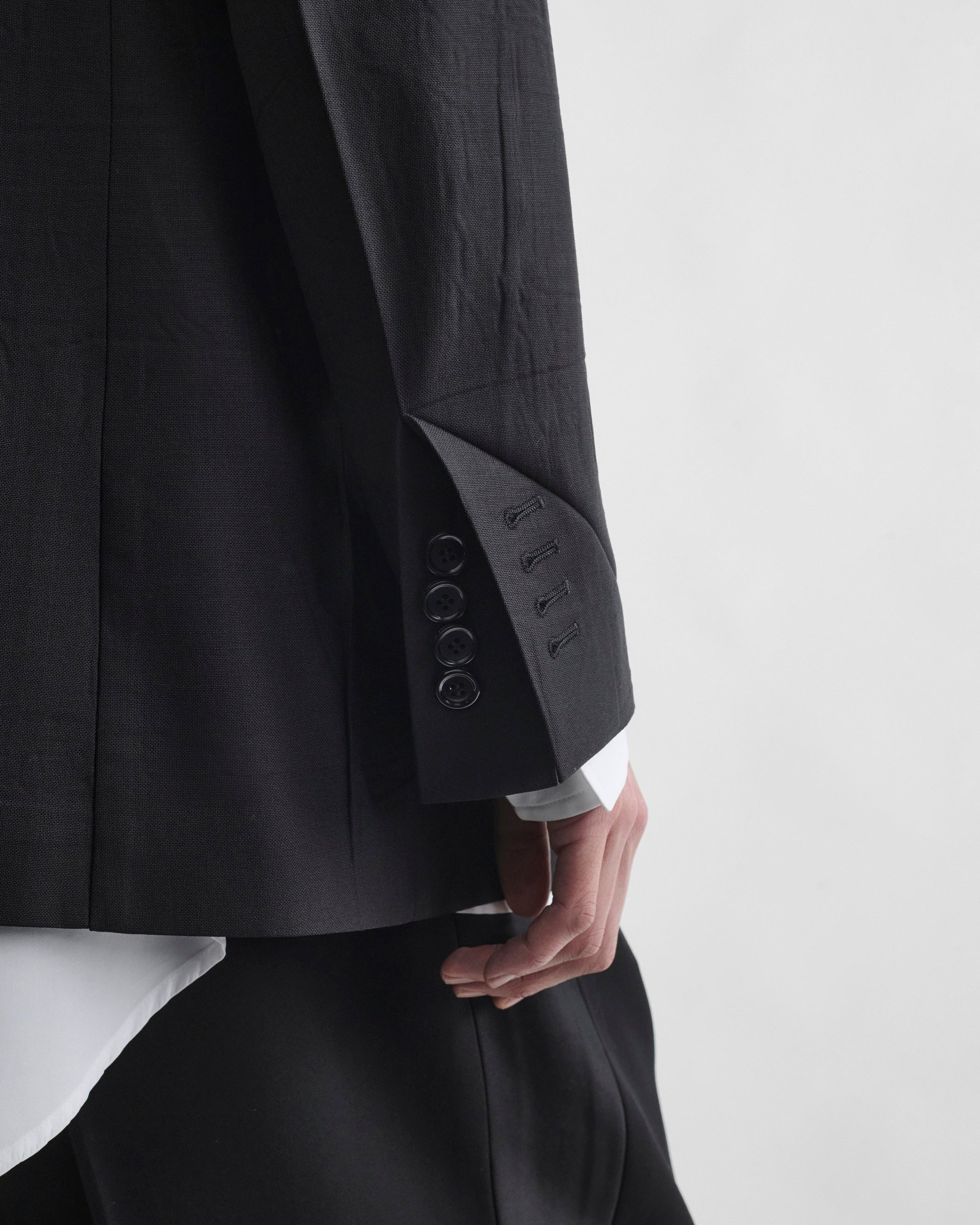 Sleeve detail view of model wearing NEAPOLITAN JACKET in black wool