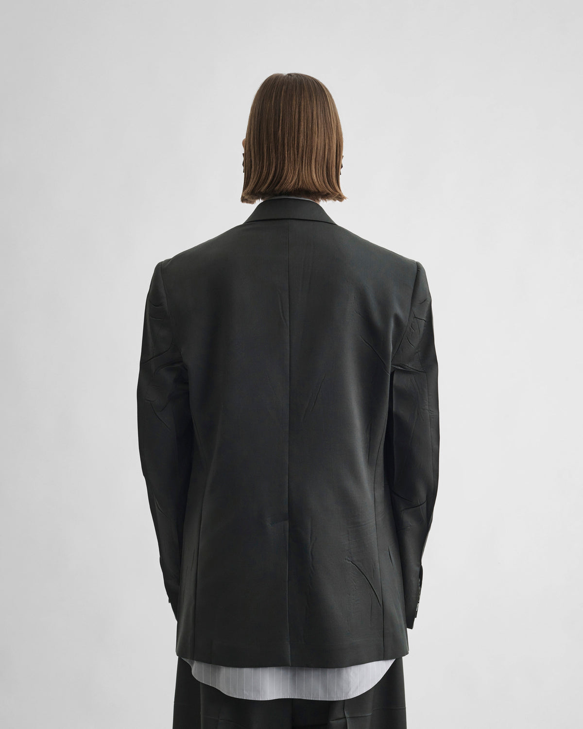 Back view of model wearing NEAPOLITAN JACKET in green bronze wool