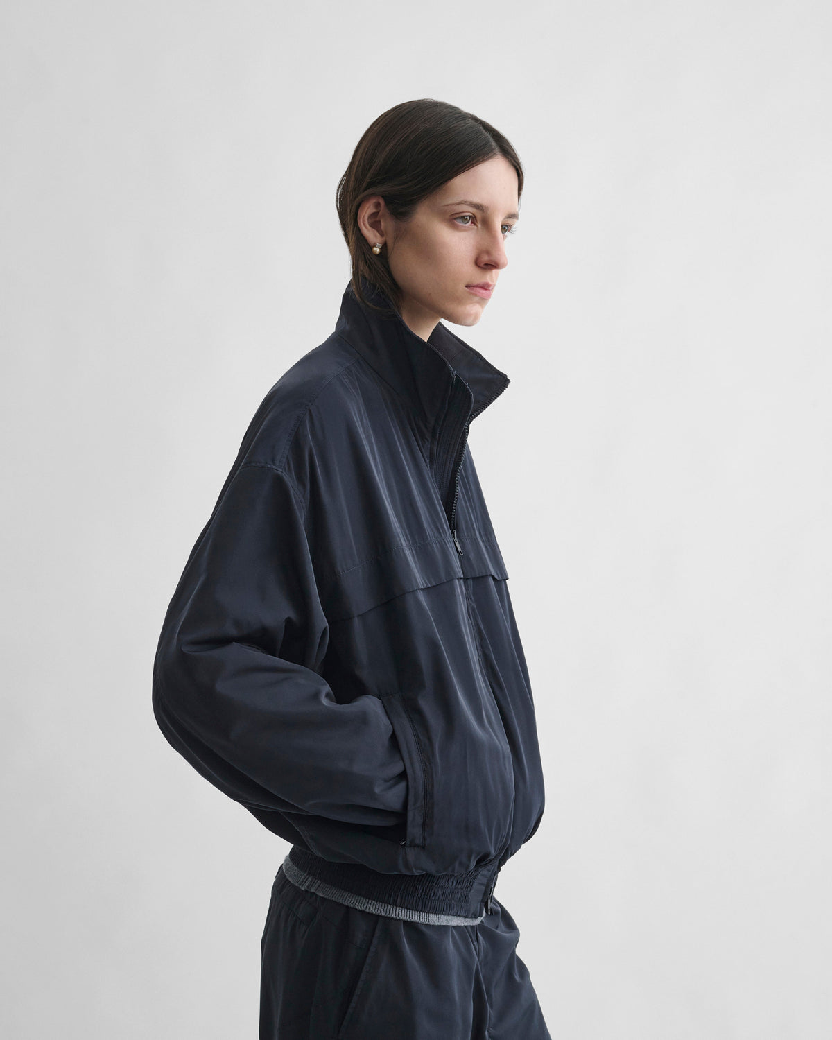 Side view of model wearing WINDBREAKER in dark navy polyester