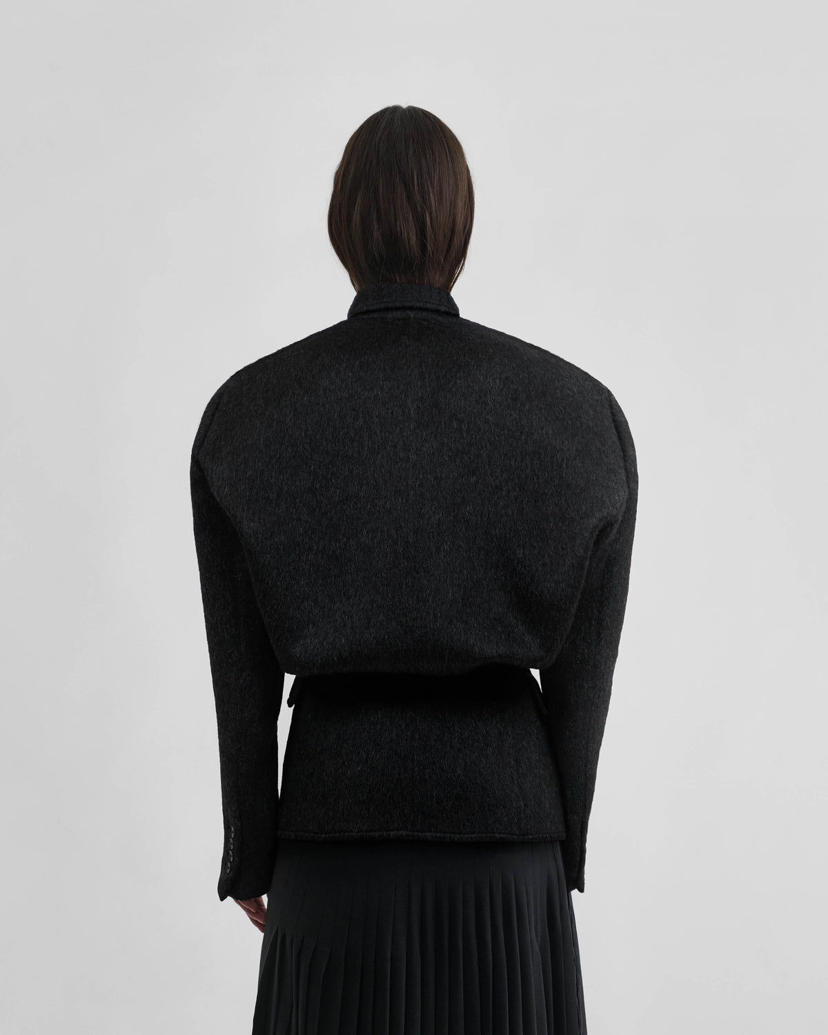 Back view of model wearing KINKED JACKET in anthracite wool