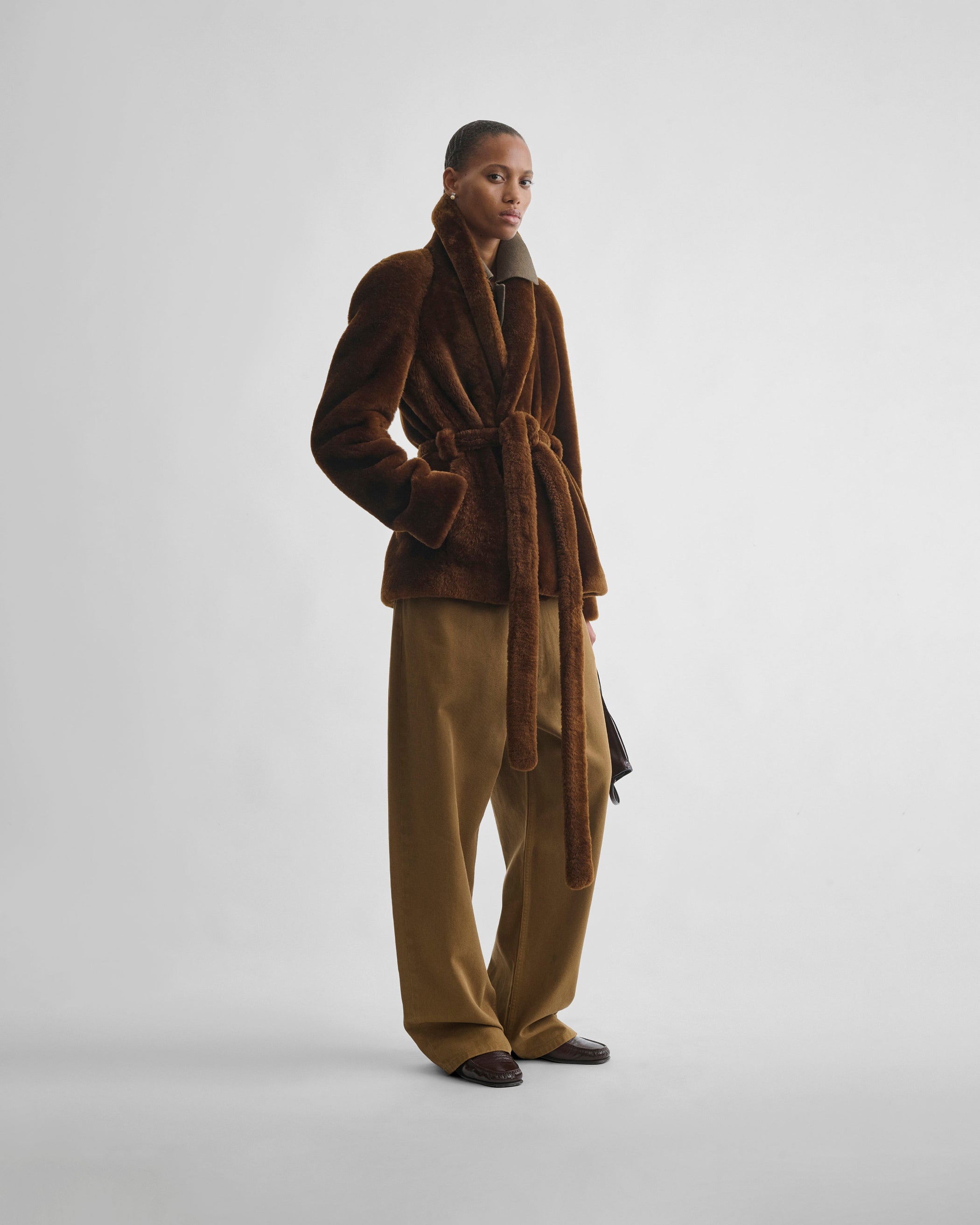 Front view of model wearing BELTED ROBE JACKET in burnt orange shearling